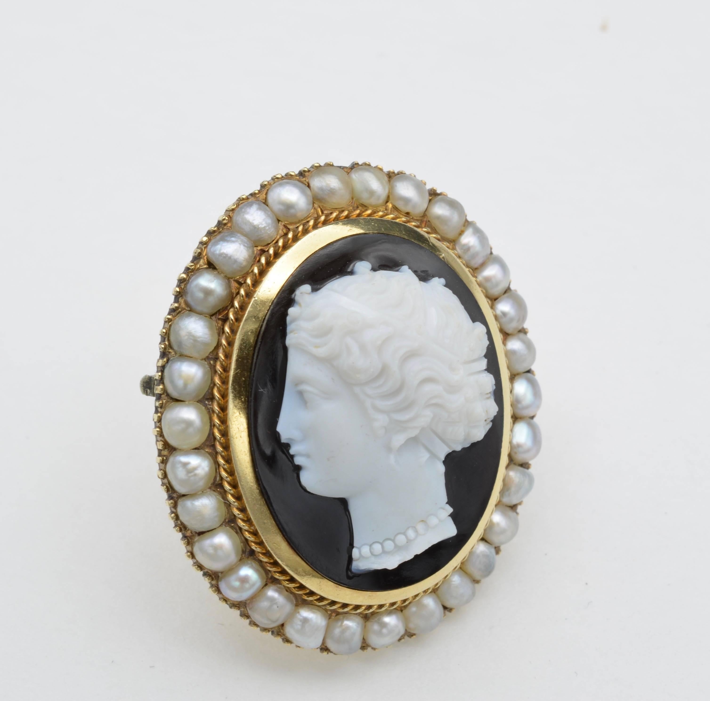 This Napoleon III hand carved onxy brooch has a profile portrait of woman wearing a pearl necklace and bandeau hairpiece. The intricate detail and the skill of the carver are profound. All of the 30 fine natural pearls are 2.5mm in diameter.