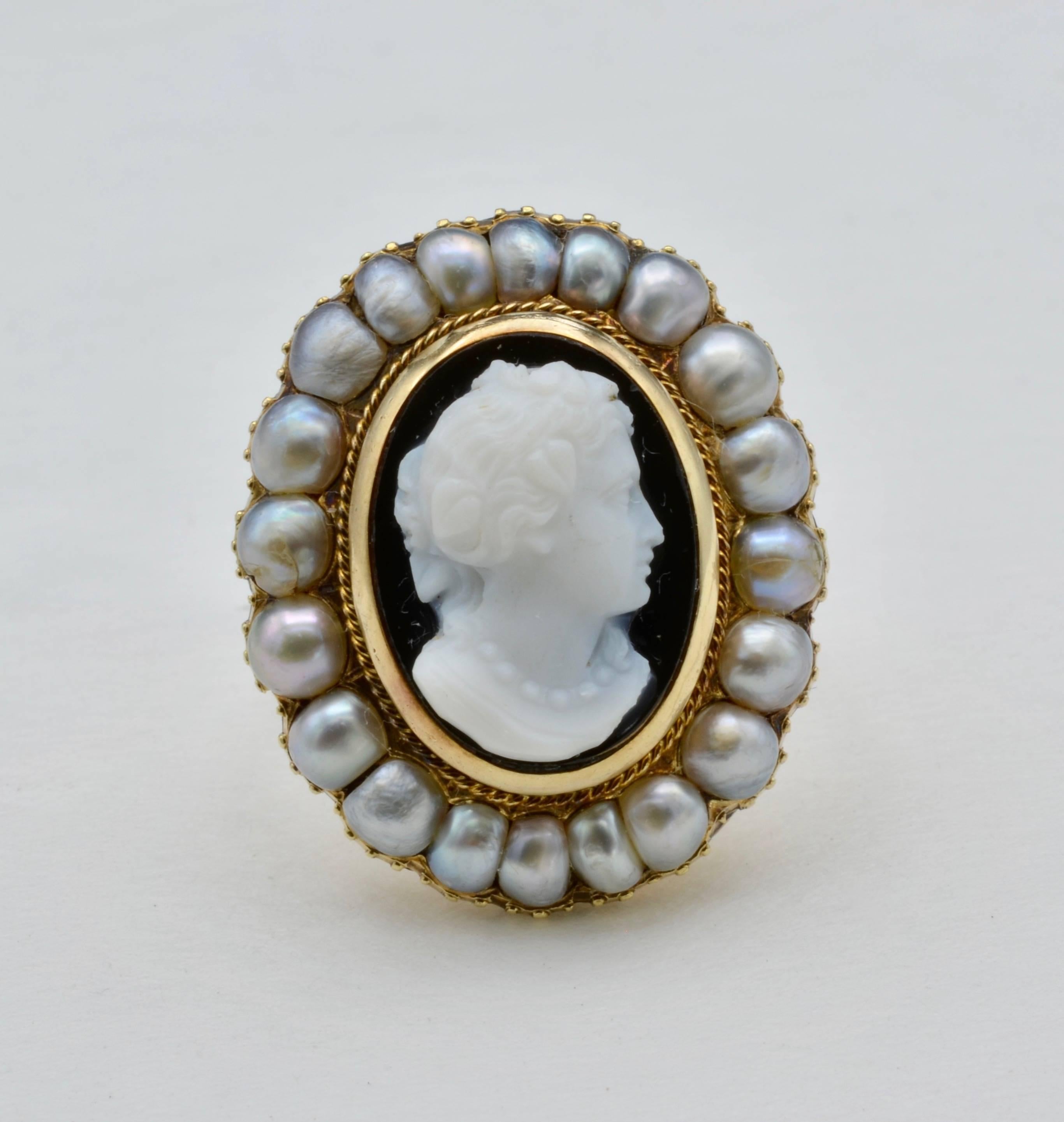 From the 1880's this hand carved onyx ring is set with a halo of fine natural pearls in 18K yellow gold. A beautiful profile portrait and size 3.75 may be sized. The 20 pearls are between 2.5-3 mm in width.