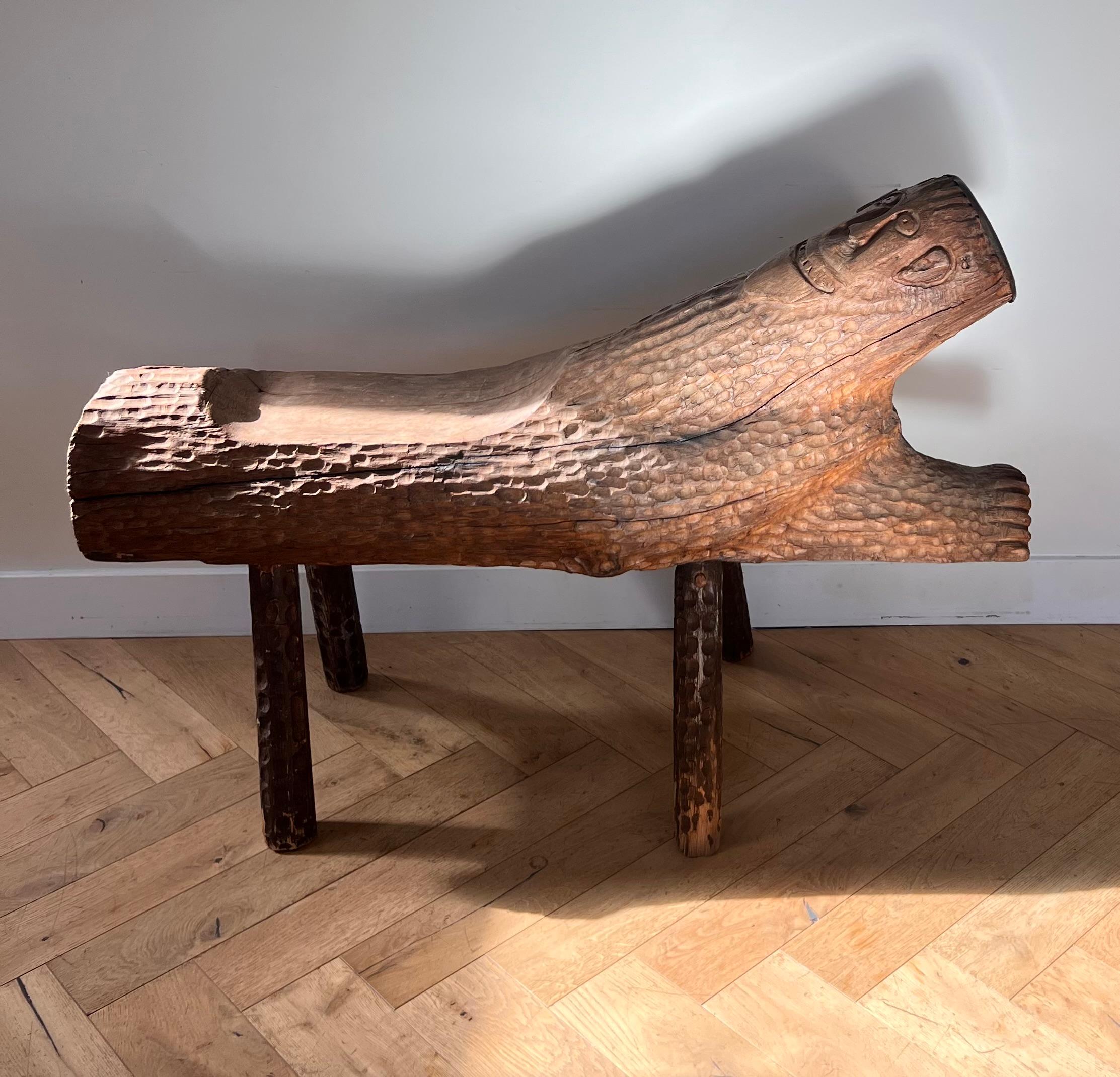 Banc d'art brut en bois, fabriqué à la main, comportant un visage et un bord en métal, vingtième siècle. Posé sur quatre pieds, le banc est une sculpture fonctionnelle robuste qui ajoutera de l'éclectisme et de la personnalité à n'importe quel