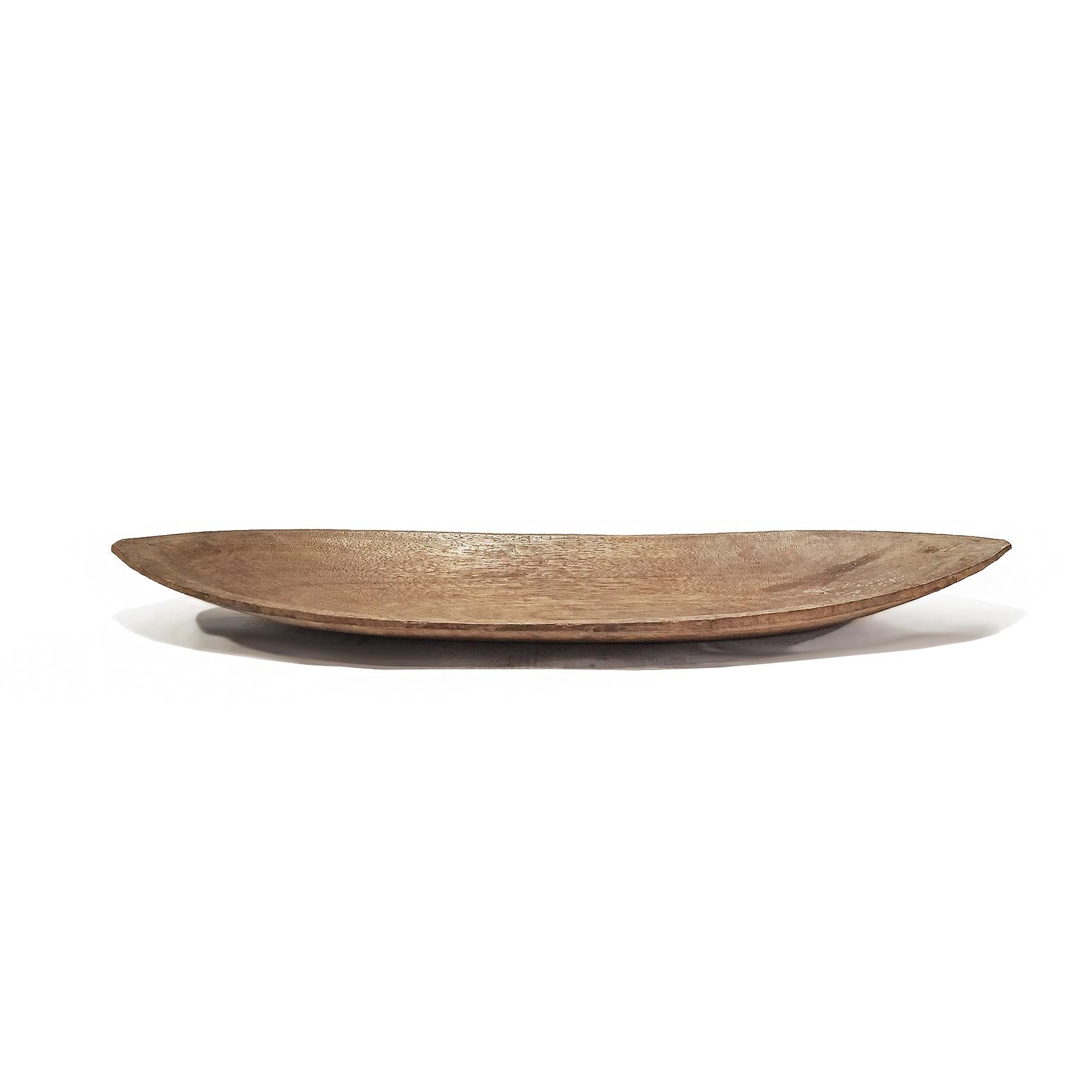 A large oval tray, hand-carved in Indonesia out of a single piece of Jackfruit wood. Rounded bottom. Natural color finish. 

42 inches wide, 13 inches deep, 3 inches high. 