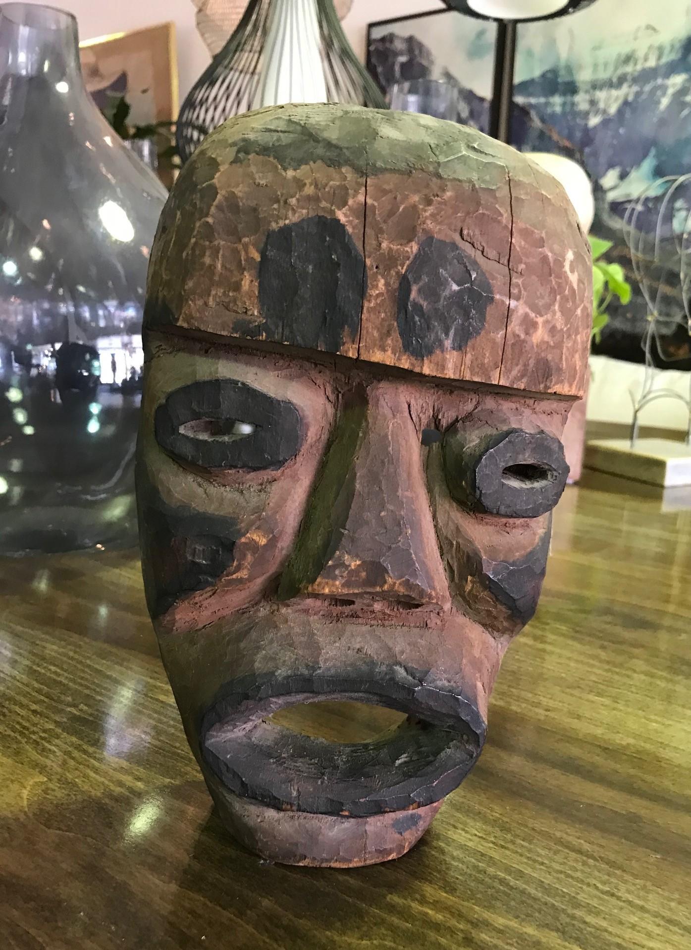 An interesting piece. Quite unique. We are at a loss to what region this might be from. The facial features are very pronounced and the mask has been nicely colored with various pigments. The mask has some age to it and a nice patina. 

We are