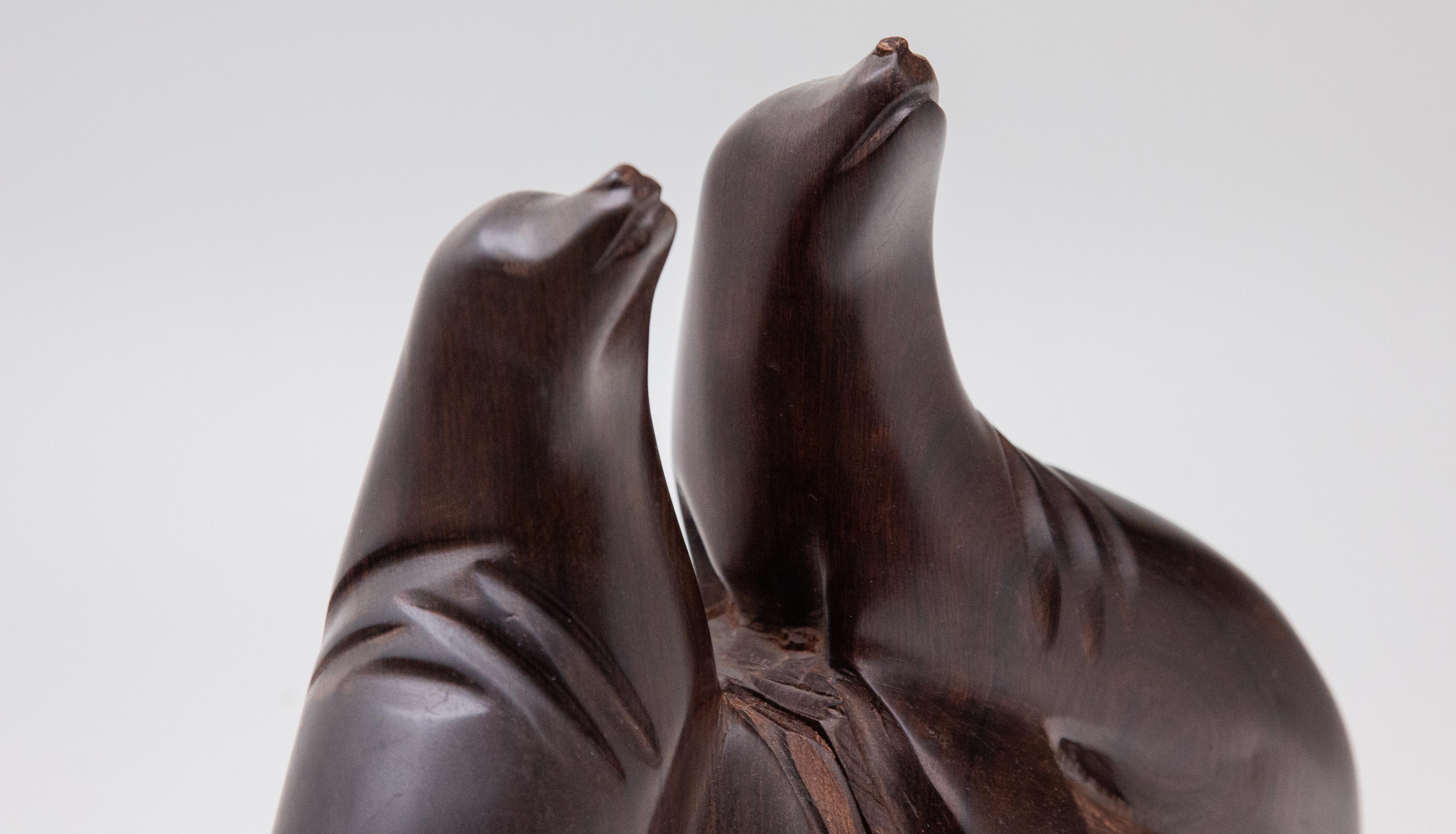 Hand-carved pair of ironwood sea lion bookends. Two mirror-image carved bookends depicting sea lion on rocks. Size: 10