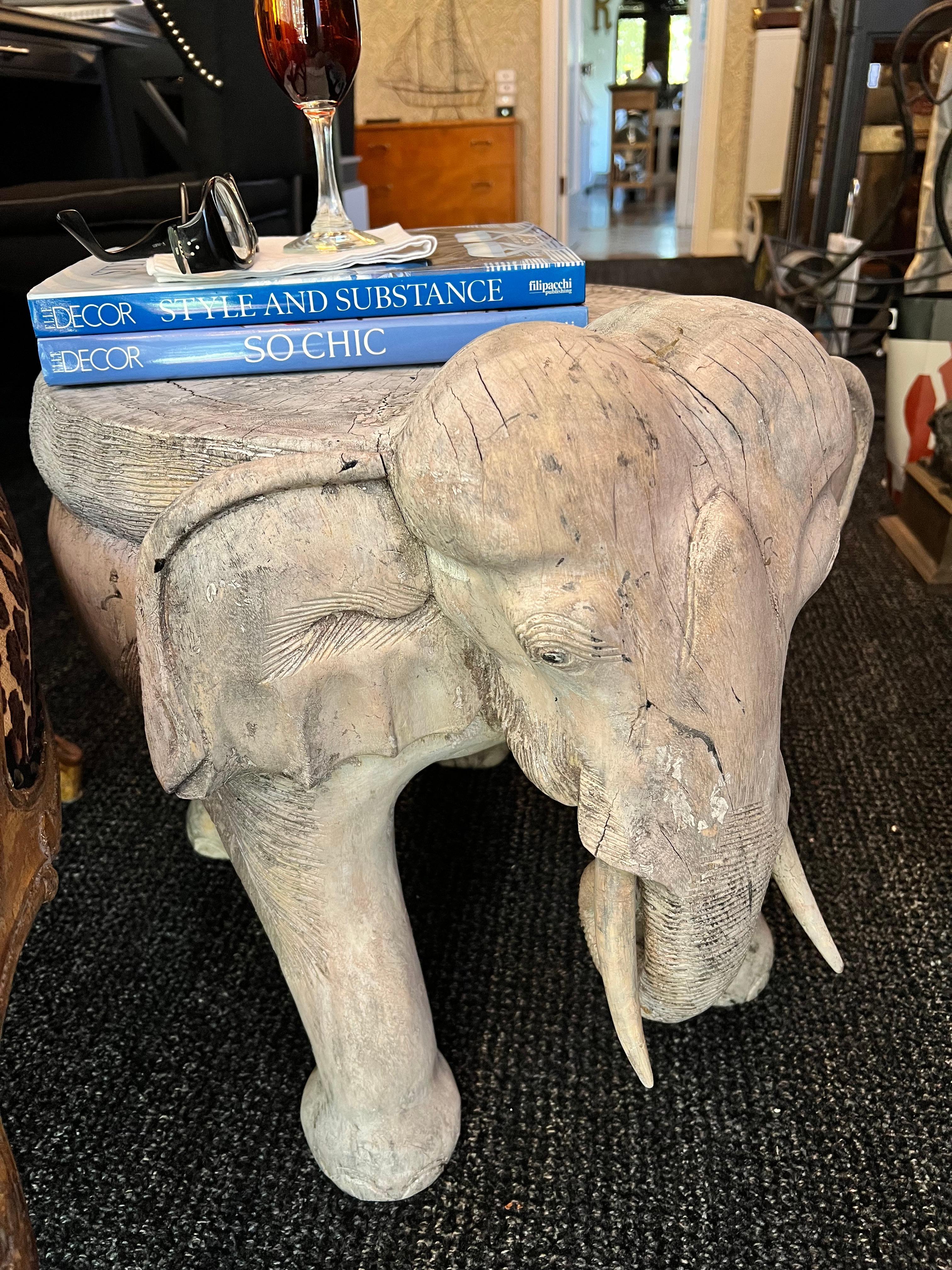 A solid piece of wood carved in the shape of an elephant.  The piece was previously painted and now has a wonderfully patinated surface.  The table would compliment many spaces, from a Childs room, to the den or even outside in a covered patio or