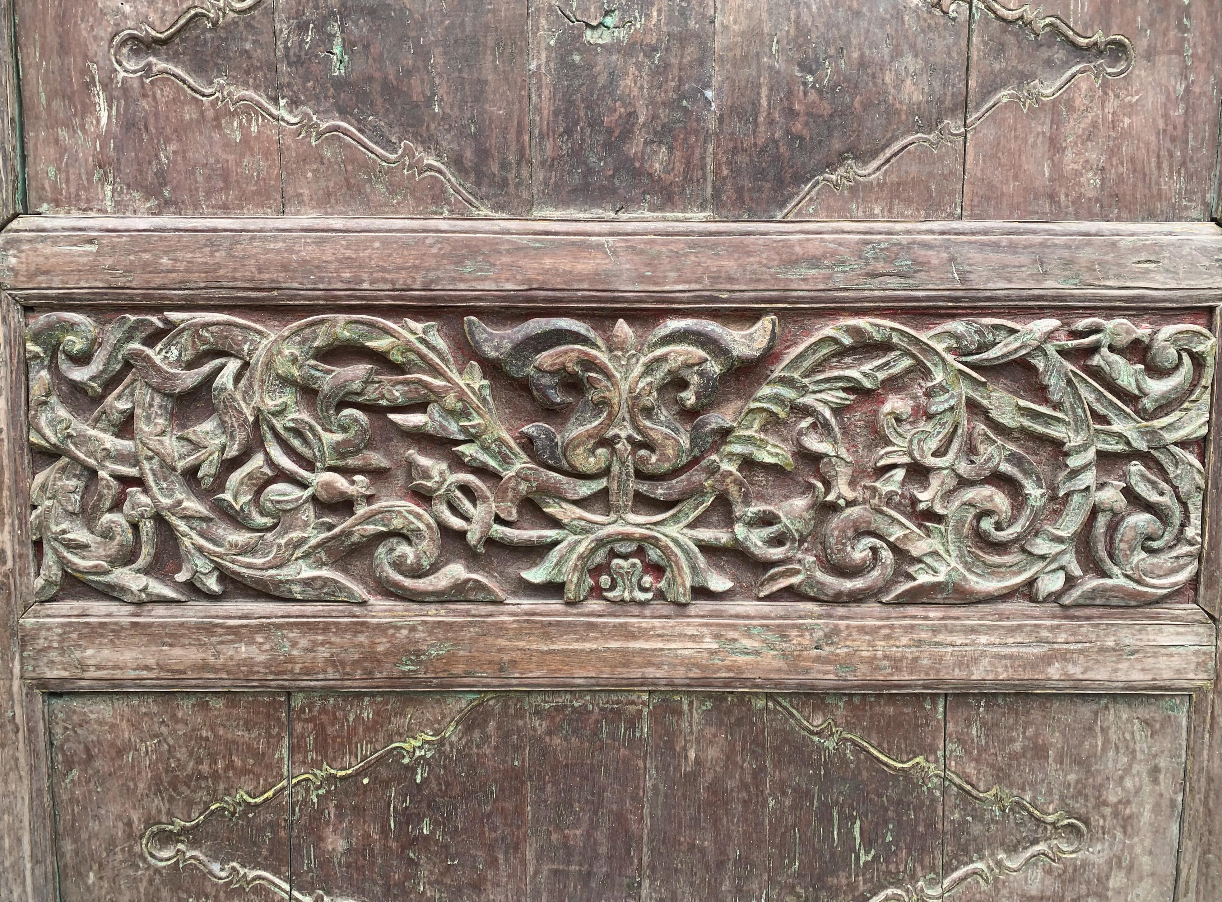 A wonderfully hand-carved wooden panel with floral motifs from the Indonesian island of Madura, off the coast of eastern Java. This decorative panel once adorned a traditional Madura house. Carved from teak wood the panel still retains its original