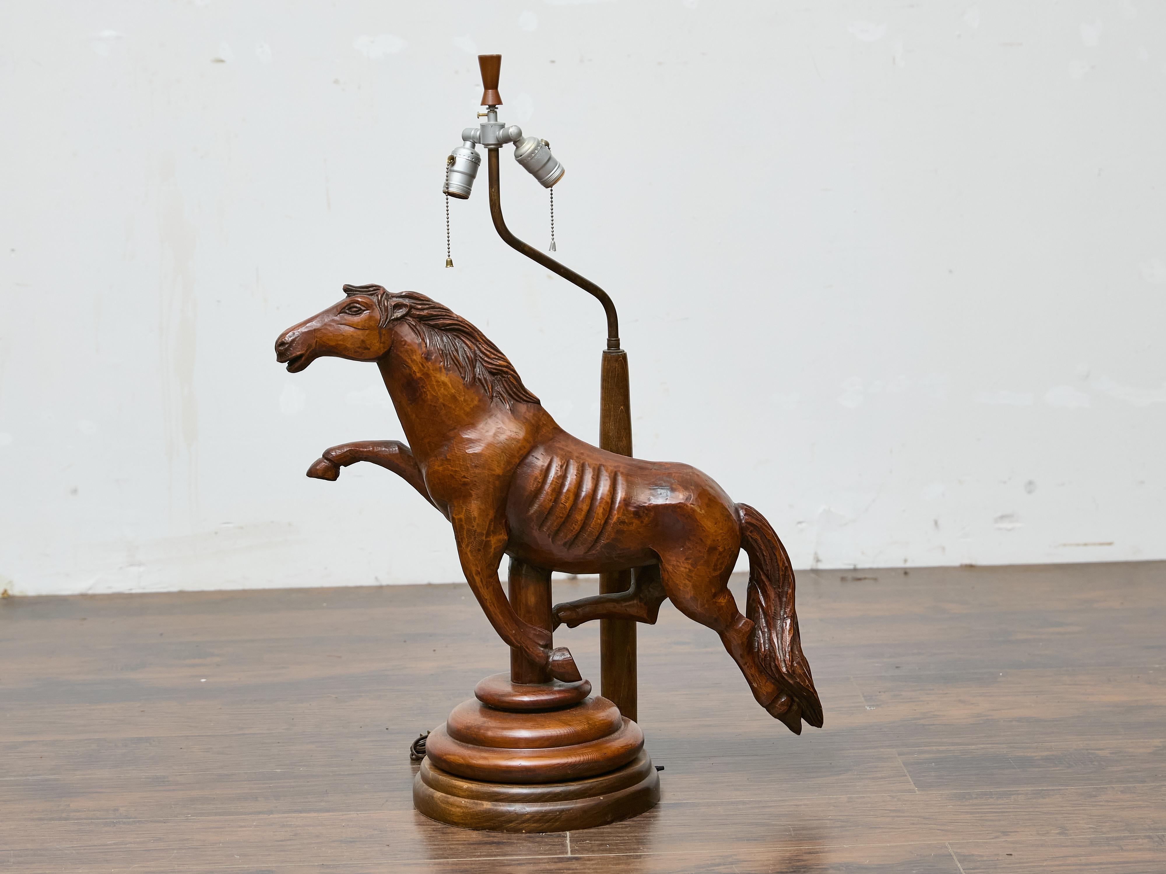Lámpara de mesa de madera tallada a mano de mediados de siglo que representa un caballo. Tallada a mano con detalles expresivos, esta lámpara de sobremesa continental de mediados del siglo XX aporta movimiento y arte a cualquier interior. El caballo