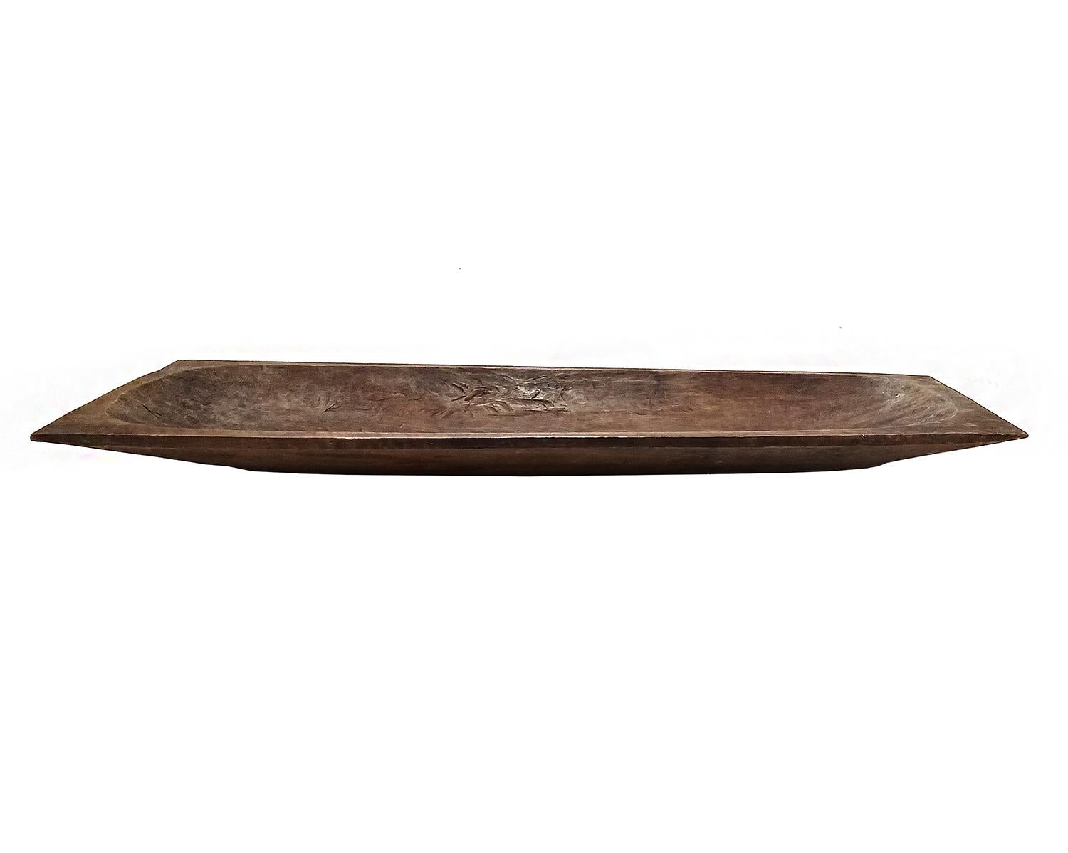 A large rectangular tray, hand-carved in Indonesia out of a single piece of Jackfruit wood. Rounded bottom. Natural color finish. 

41 inches wide, 13 inches deep, 3 inches high. 