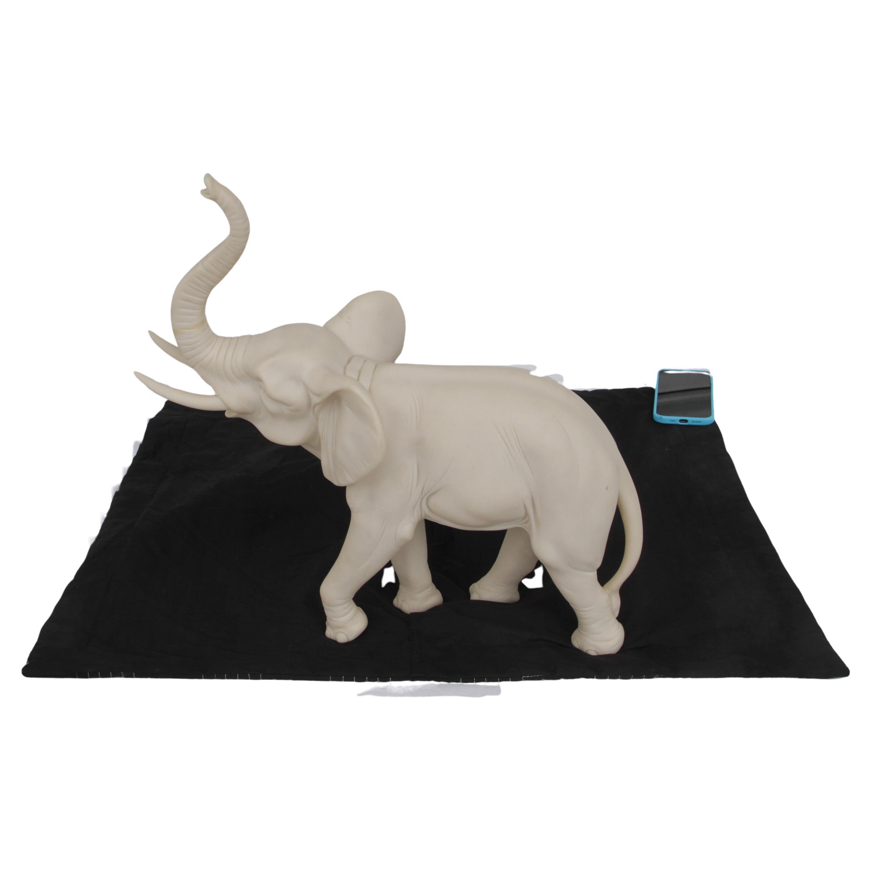 Beautifully hand-carved elephant figurine. Crafted from durable resin with a smooth stone-like finish, this statue showcases intricate details that highlight the elephant's graceful form—from its raised trunk, symbolizing good luck and prosperity,