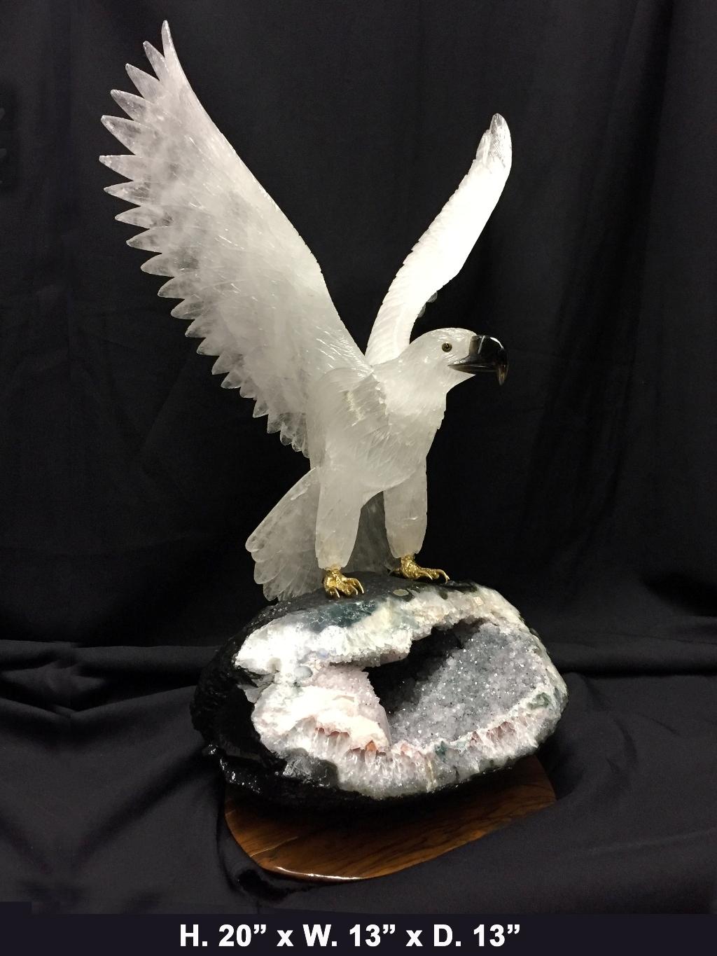 Magnificent one of a kind large finely hand-carved and hand polished rock crystal eagle with spread wings and black obsidian eyes and beak on beautiful a Amethyst Geode base, all resting on a brown gemstone base.
The eagle's feet are gold plated