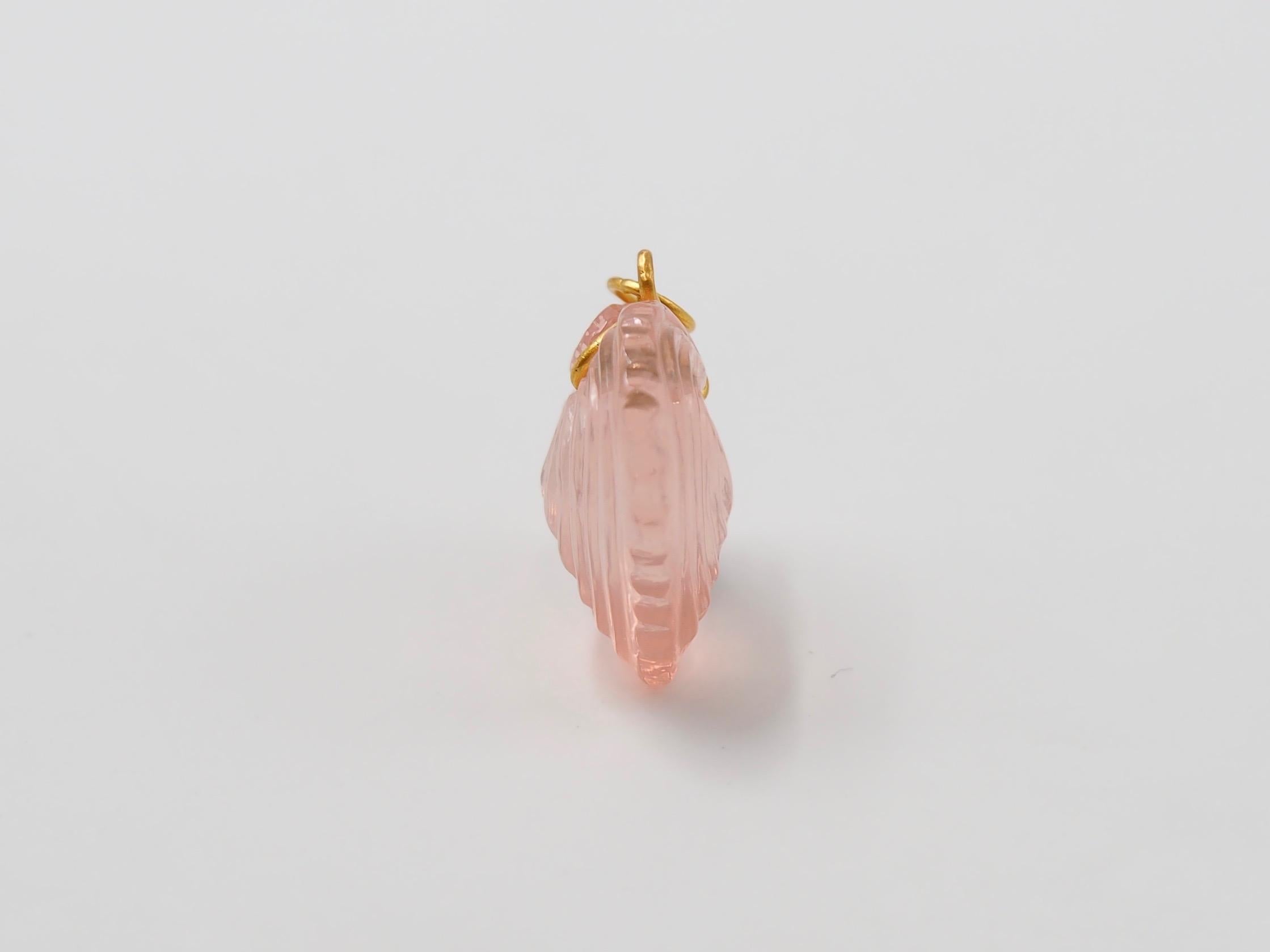 Hand-carved and handmade, this pendant represents a heart seashell in rose quartz. The stone is simply drilled to allow a curved 22 karat gold wire that is twisted and finishes with a ring. 

2 sizes exist as you can see on one of the photo. This