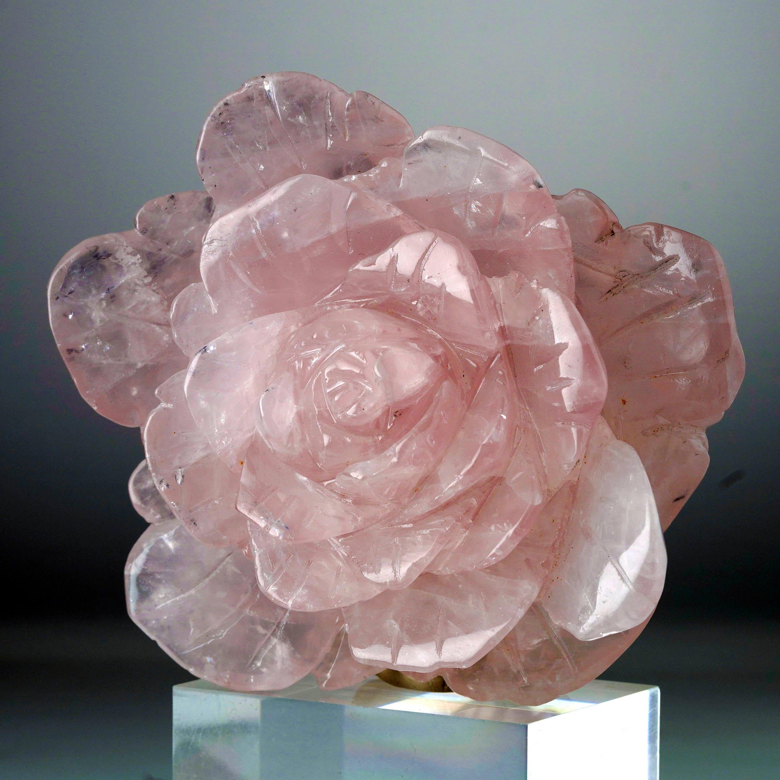 Questa rosa lucente e realistica è stata scolpita a mano in quarzo rosa del Madagascar di qualità AAA. La traslucenza dei petali, delicatamente intagliati e ricchi di dettagli, si manifesta con sottili venature interne. Questo pezzo di squisita