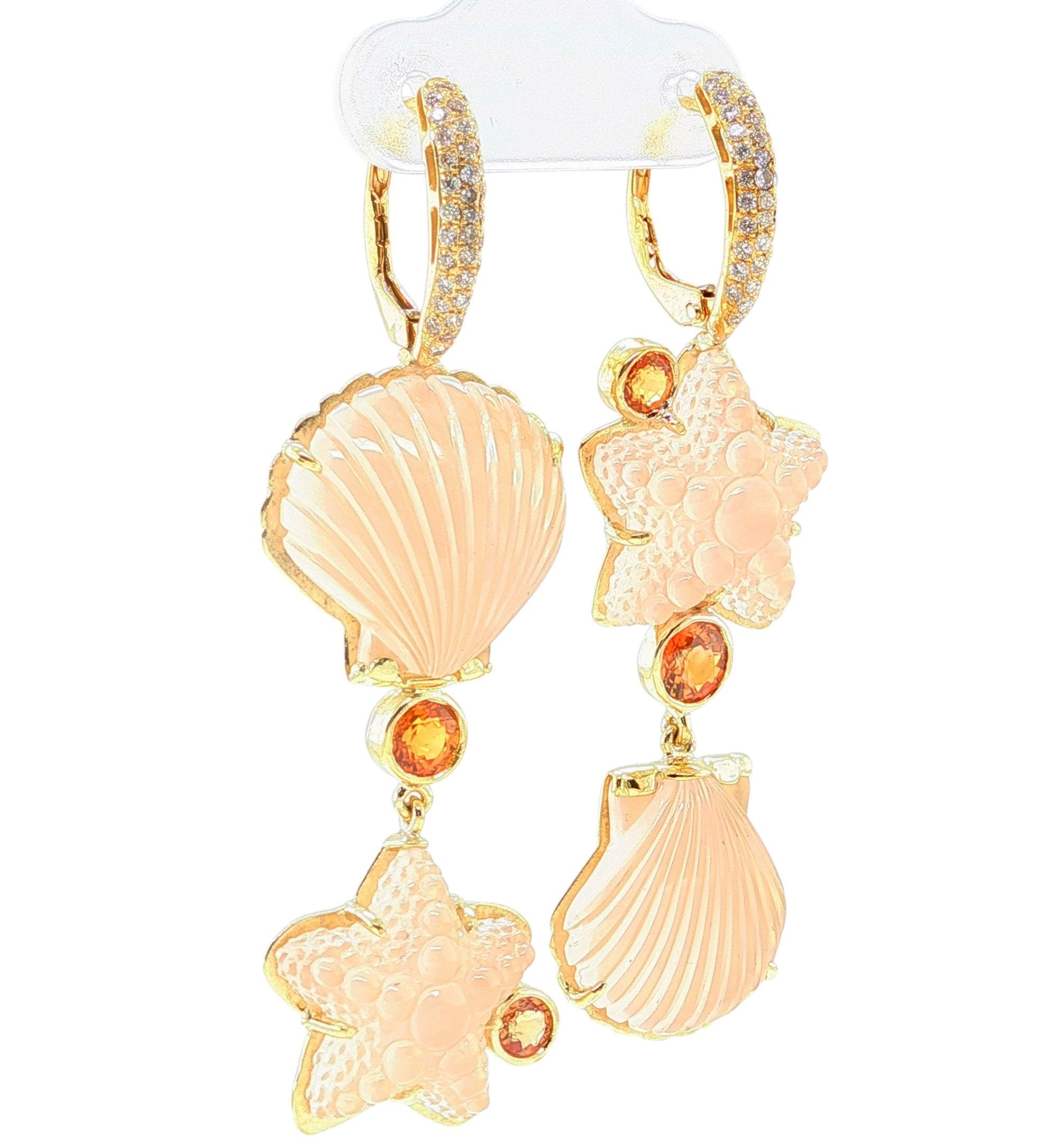 Ces boucles d'oreilles pendantes uniques en leur genre sont ornées de pierres de quartz rose sculptées à la main en forme de coquillages et d'étoiles de mer joliment texturés. Elles ont été sculptées par un maître sculpteur à Idar-Oberstein, en