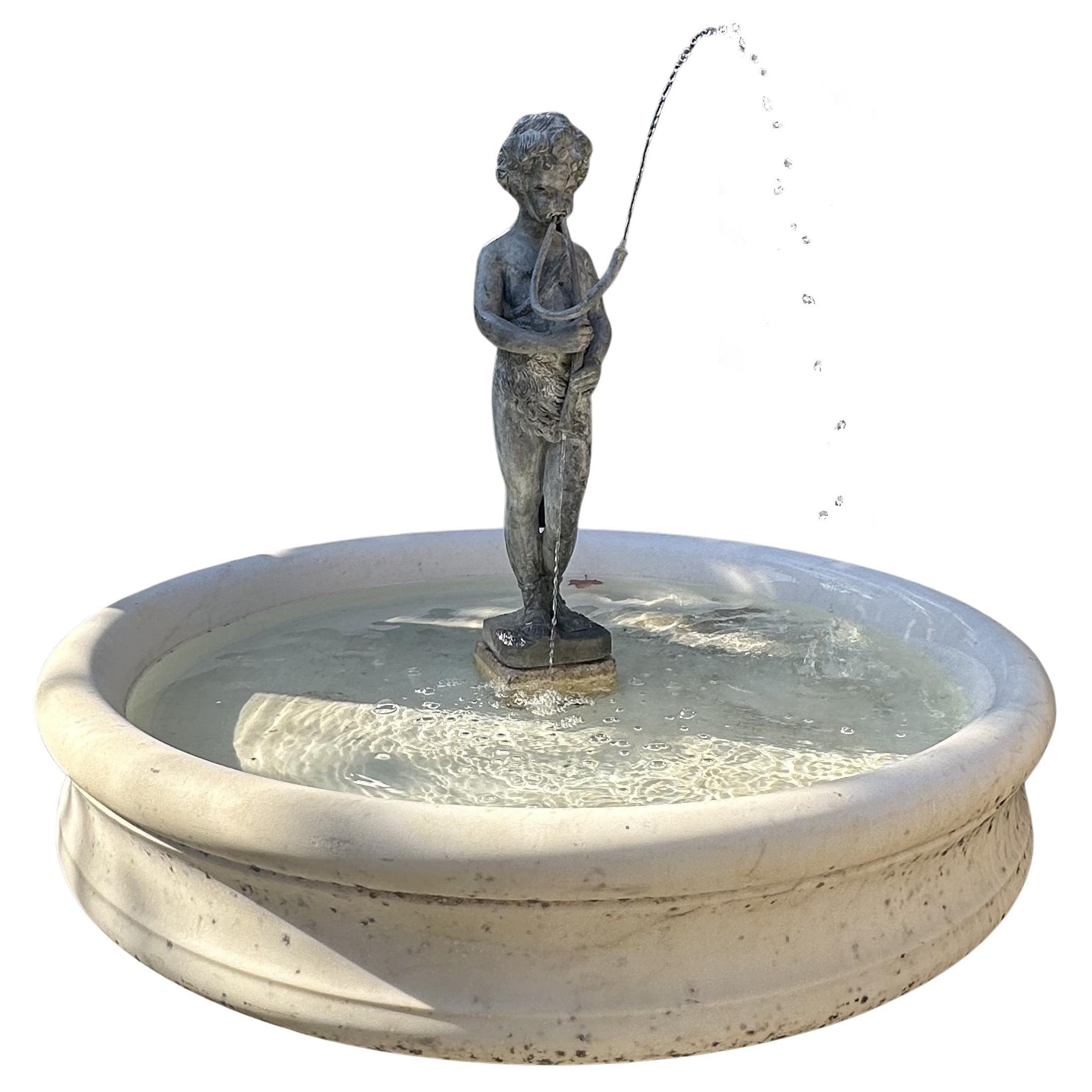 Fontaine d'eau ronde en marbre blanc sculptée à la main . Grand bassin de fontaine en marbre blanc du XIXe siècle, charmant et sculpté à la main, avec une figure en plomb représentant un enfant jouant d'un instrument de musique à double cannelure