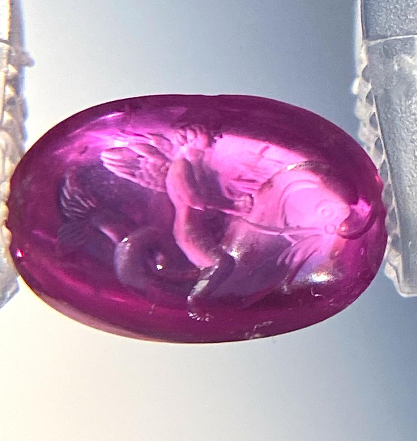 Aus der Castellani ® Collection of Carved Edelsteine ist diese fabelhafte Oval Form Double Cabochon Intaglio Ruby mit einem Gewicht von  3,41ct
Das Motiv ist ein Amor, der auf einem Delphin reitet. Es wurde von Castellani® Jewellers für unsere