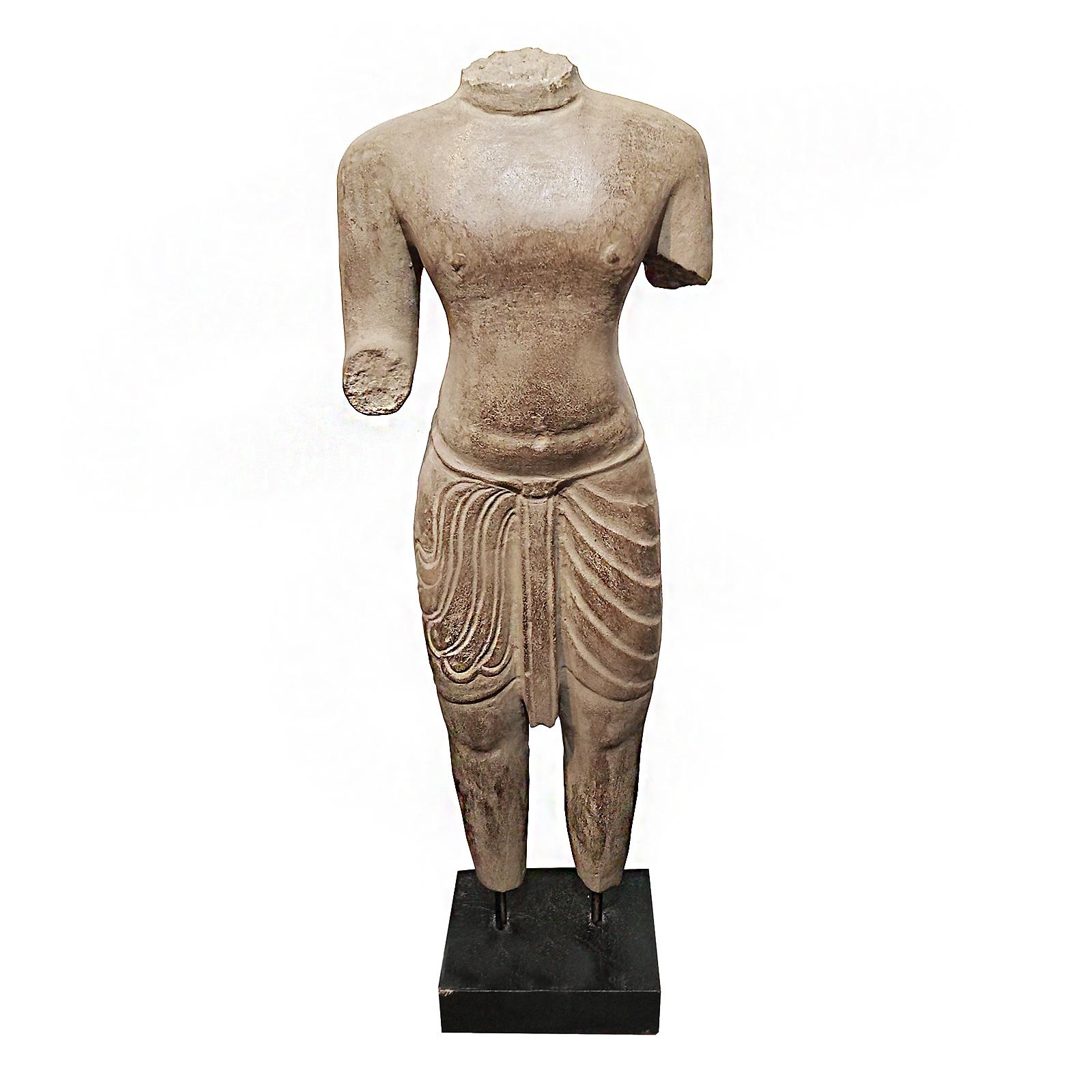 A table-top sculpture of a torso in traditional attire, hand-carved from a single piece of stone. From Thailand. Contemporary.

Mounted on a wood / metal stand. 28.5 inches high, 10 inches wide, on a 5