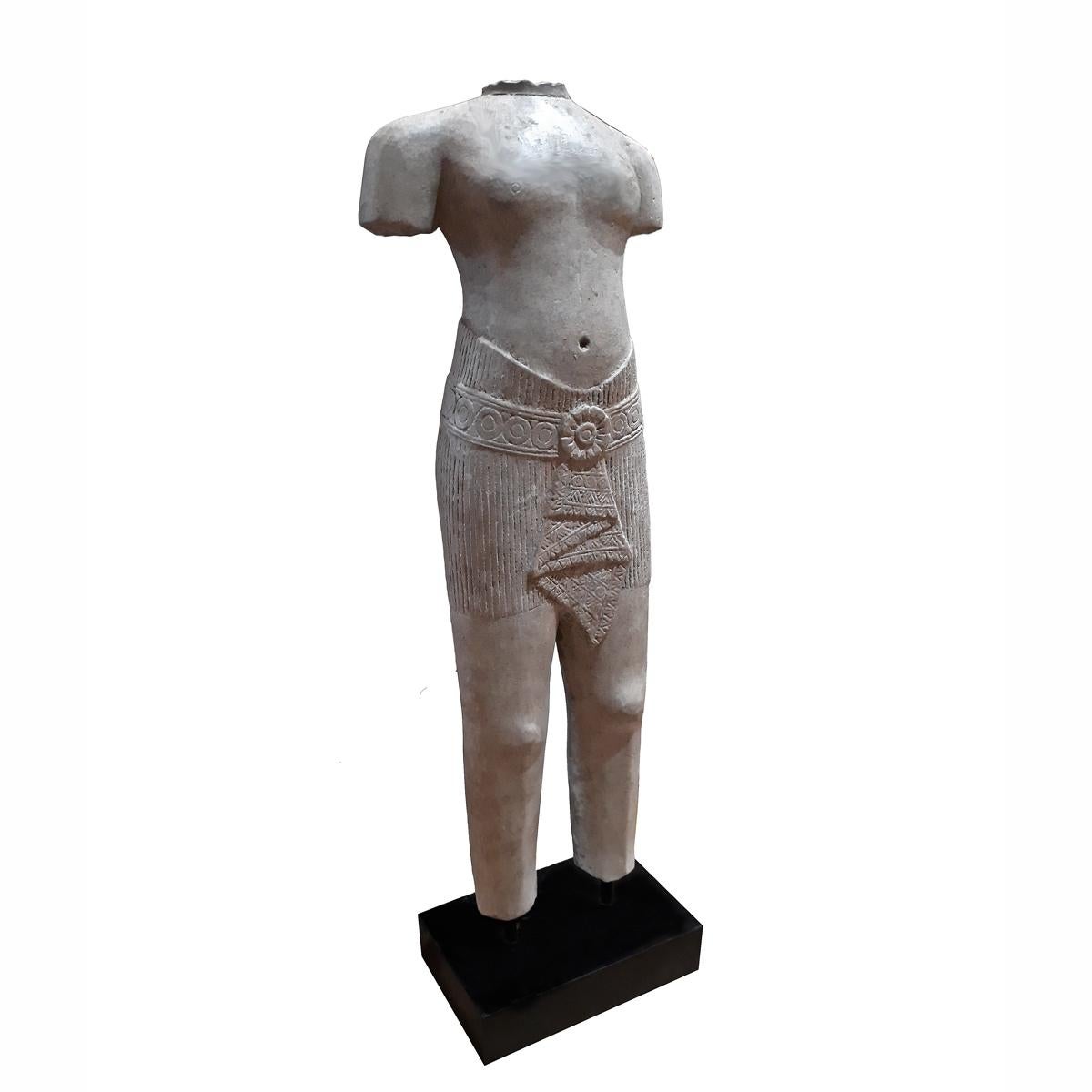 A sculpture of a male torso in traditional attire, hand carved from a single piece of sandstone. From Thailand. Mounted on a wood / metal stand. Size: 27 inches high.