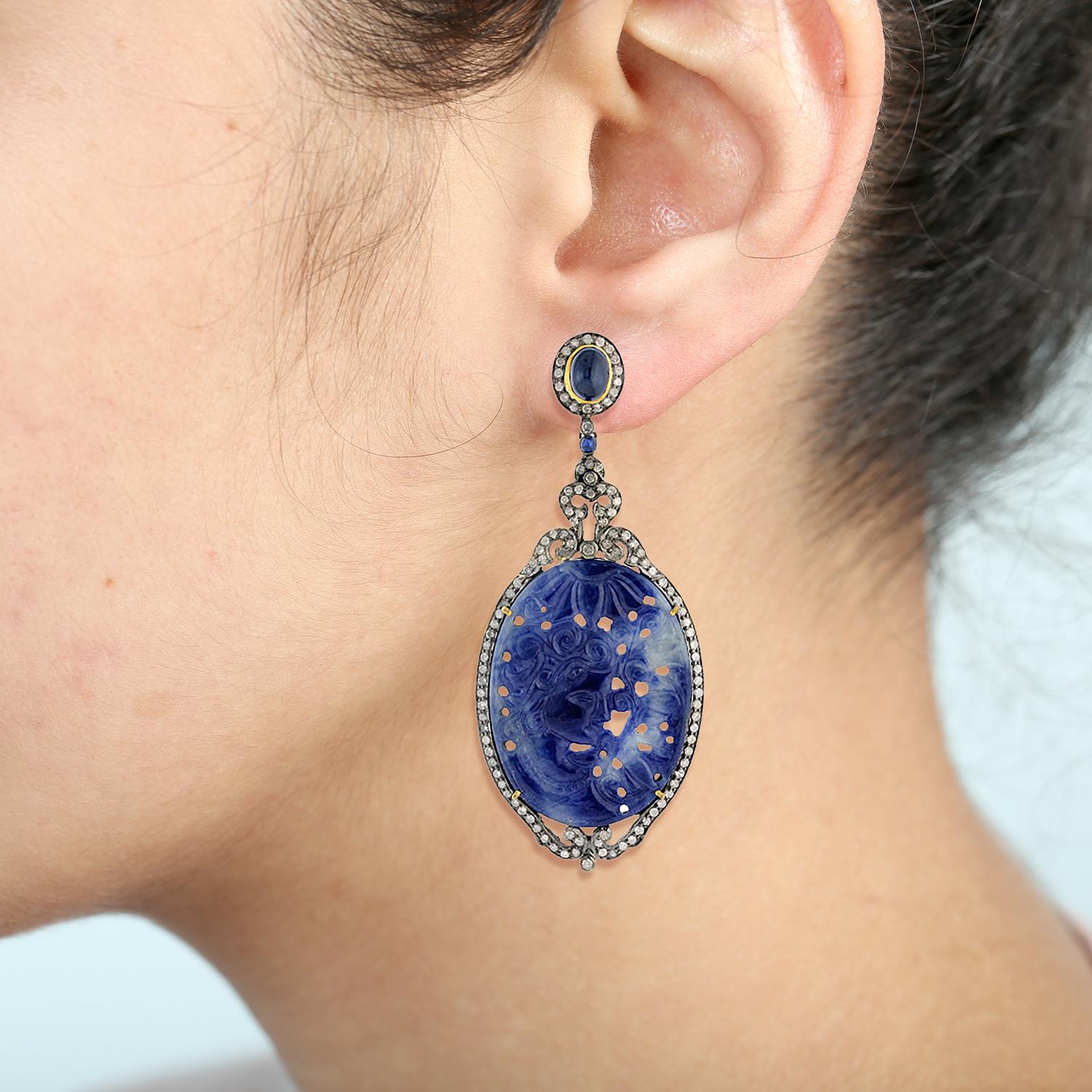 This Hand Craved lady face on this slice sapphire earring with diamonds around set in silver and gold is a very pretty earring.

Closure: Push Post

18K: 2.60gms
Diamond: 3.52cts
SiIver: 9.19gms
Blue Sapphire: 119.41cts