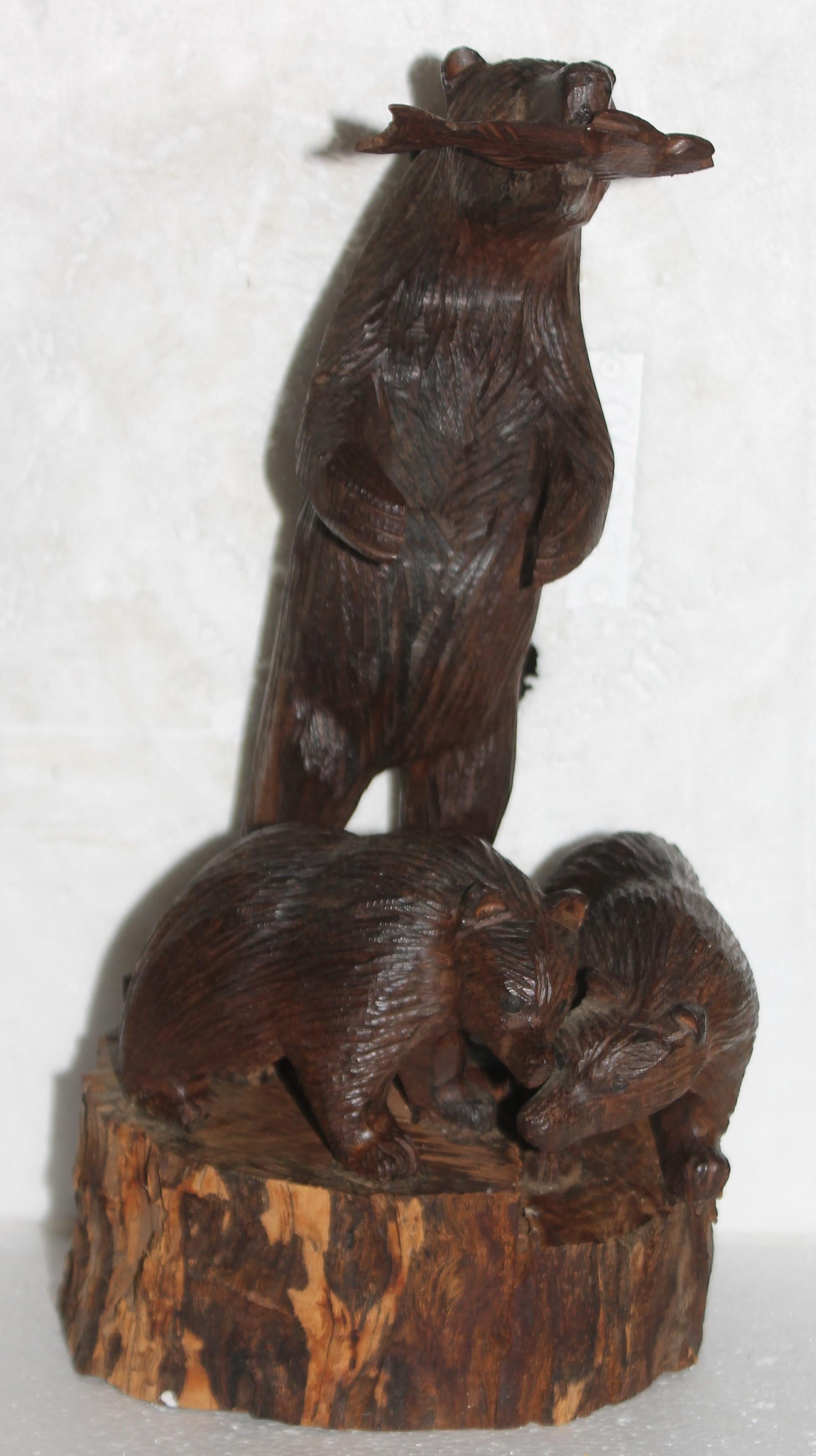 These hand carved bears are amazing and in great condition. These bears are carved out of one piece of wood or one log. The bottom is a plank of wood. The large bear has a carved wood fish in its mouth and there is two smaller bears at the base.