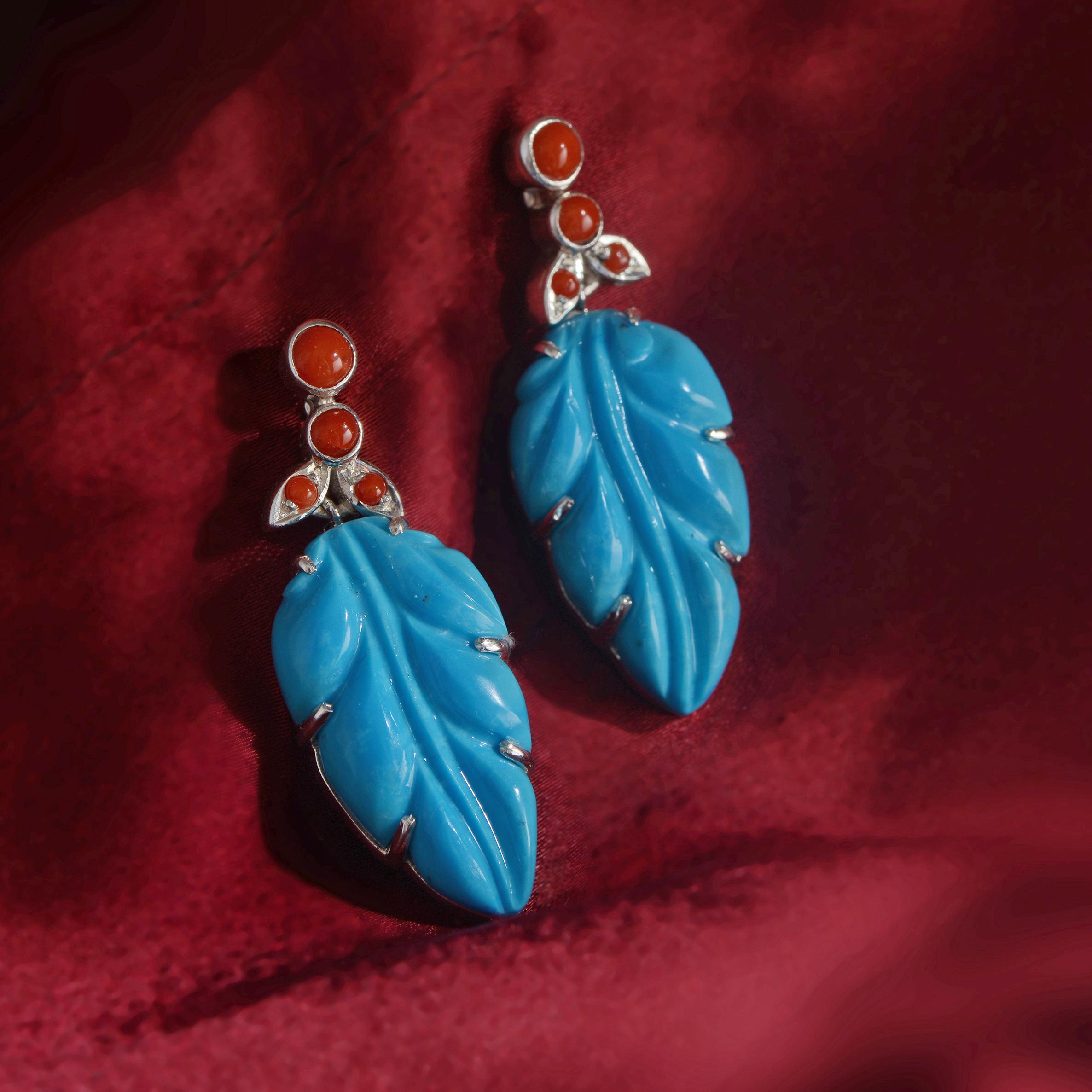 Using the ancient art of stone-carving these stunning one-of-a-kind turquoise earrings, have been handmade in our workshops. The turquoise has been hand-carved into the shape of a leaf and then hand-engraved and embedded with red corals. These