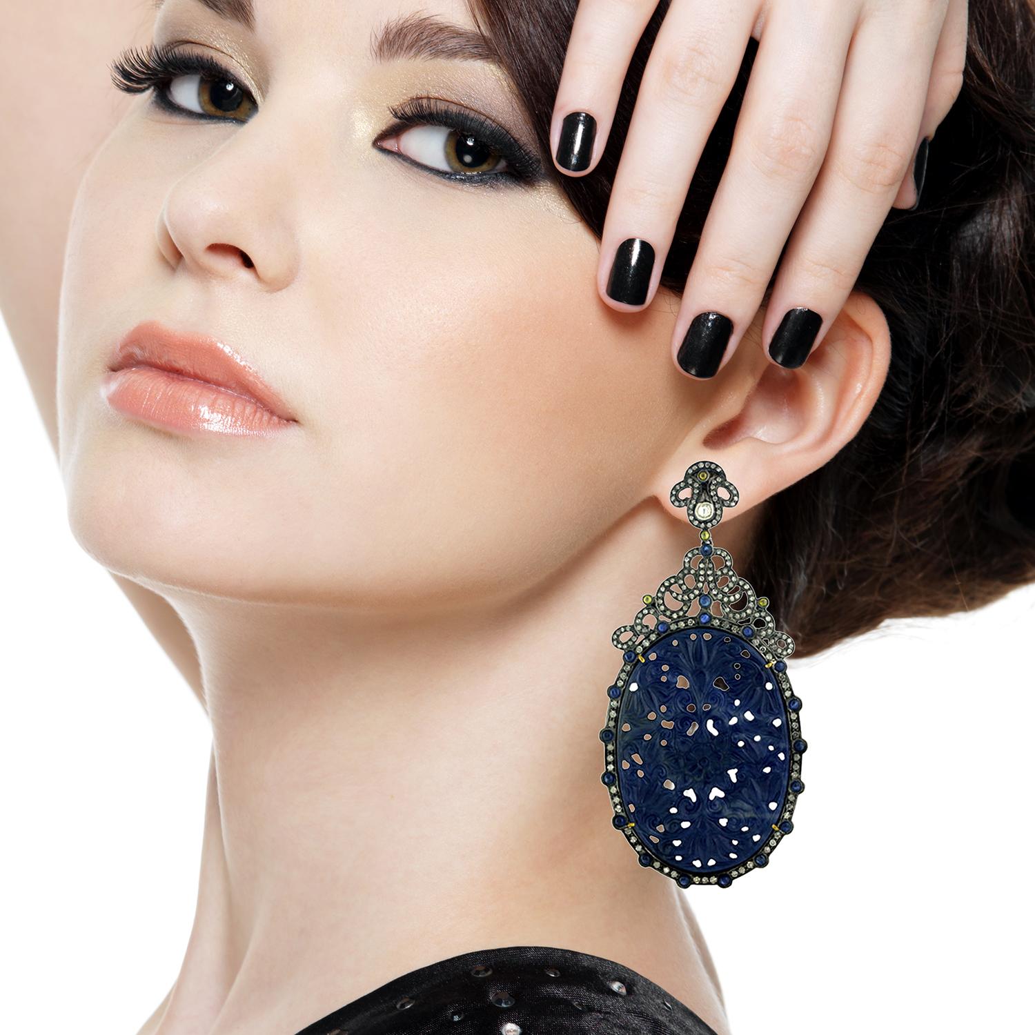 Ce magnifique saphir ovale taillé à la main est une boucle d'oreille très remarquée. Cette boucle d'oreille est de 3,5 pouces de long avec un magnifique design floral pavé de diamants autour.

Fermeture : Poteau poussoir

18kt:2.25gms
Diamant :