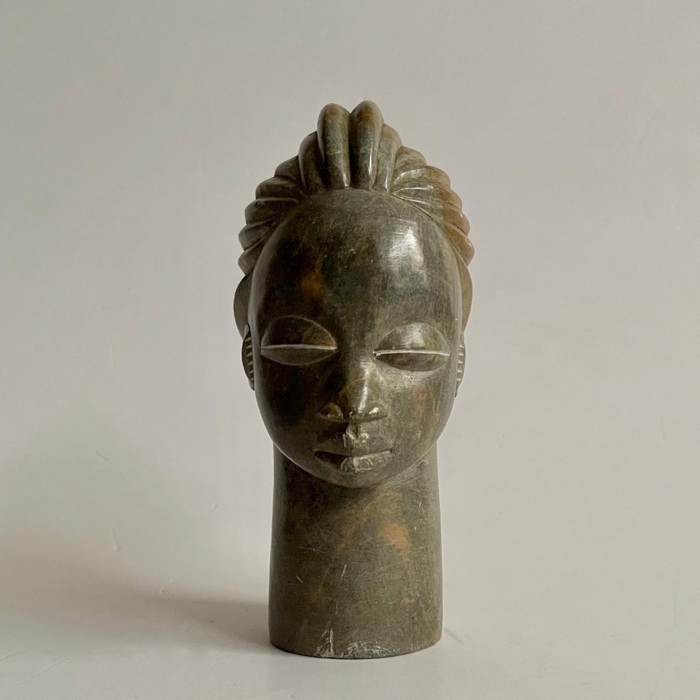 A beautiful soapstone hand-carved head of an African tribe-woman circa 1940. 
Dimensions: H 18cm x D 11cm x W 6.5cm 