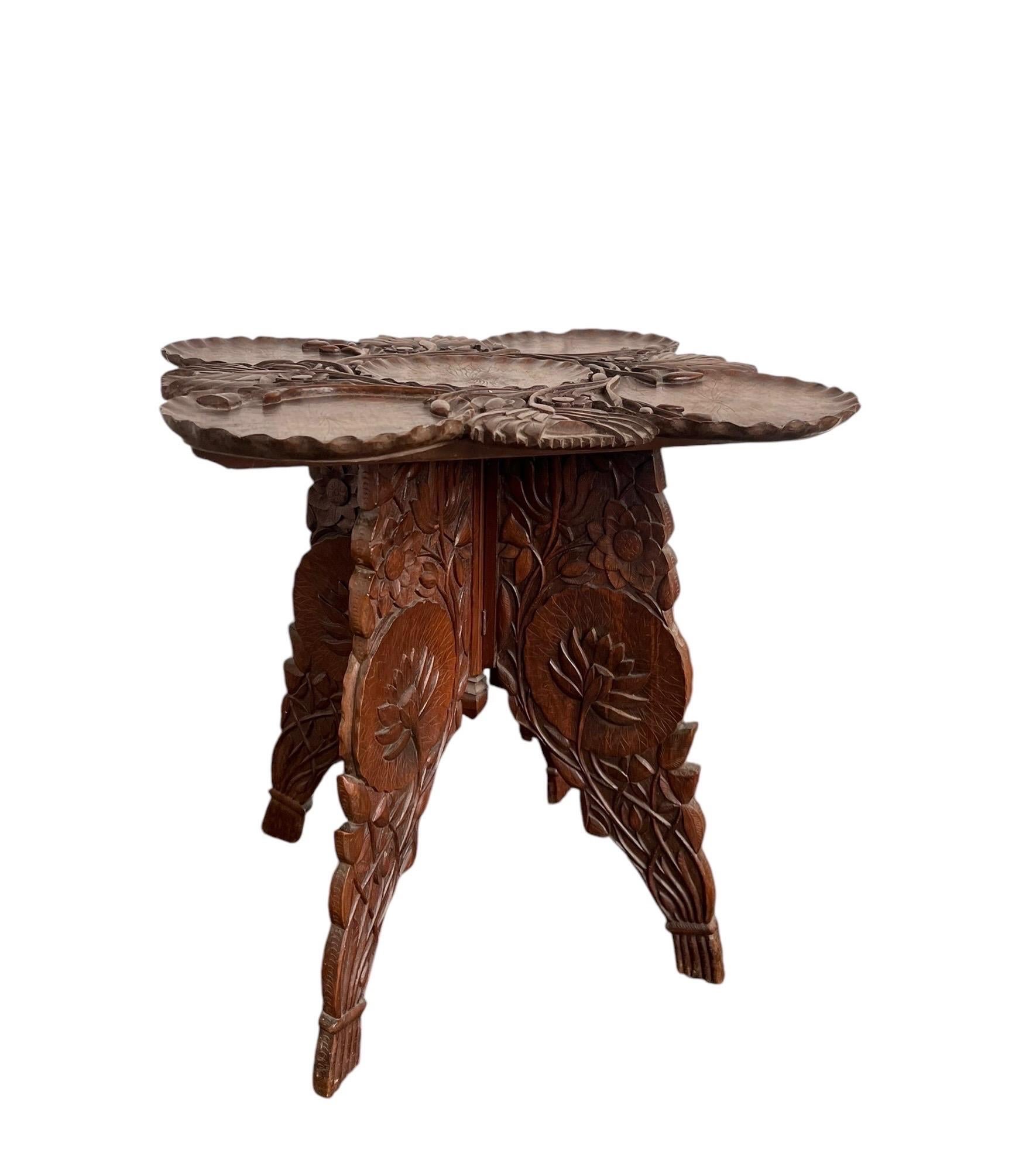 Une table d'appoint originale et ancienne, sculptée. Un motif floral en relief profondément sculpté entoure la partie supérieure proéminente. Le design en deux parties se plie facilement, ce qui est idéal pour un usage occasionnel. Les détails