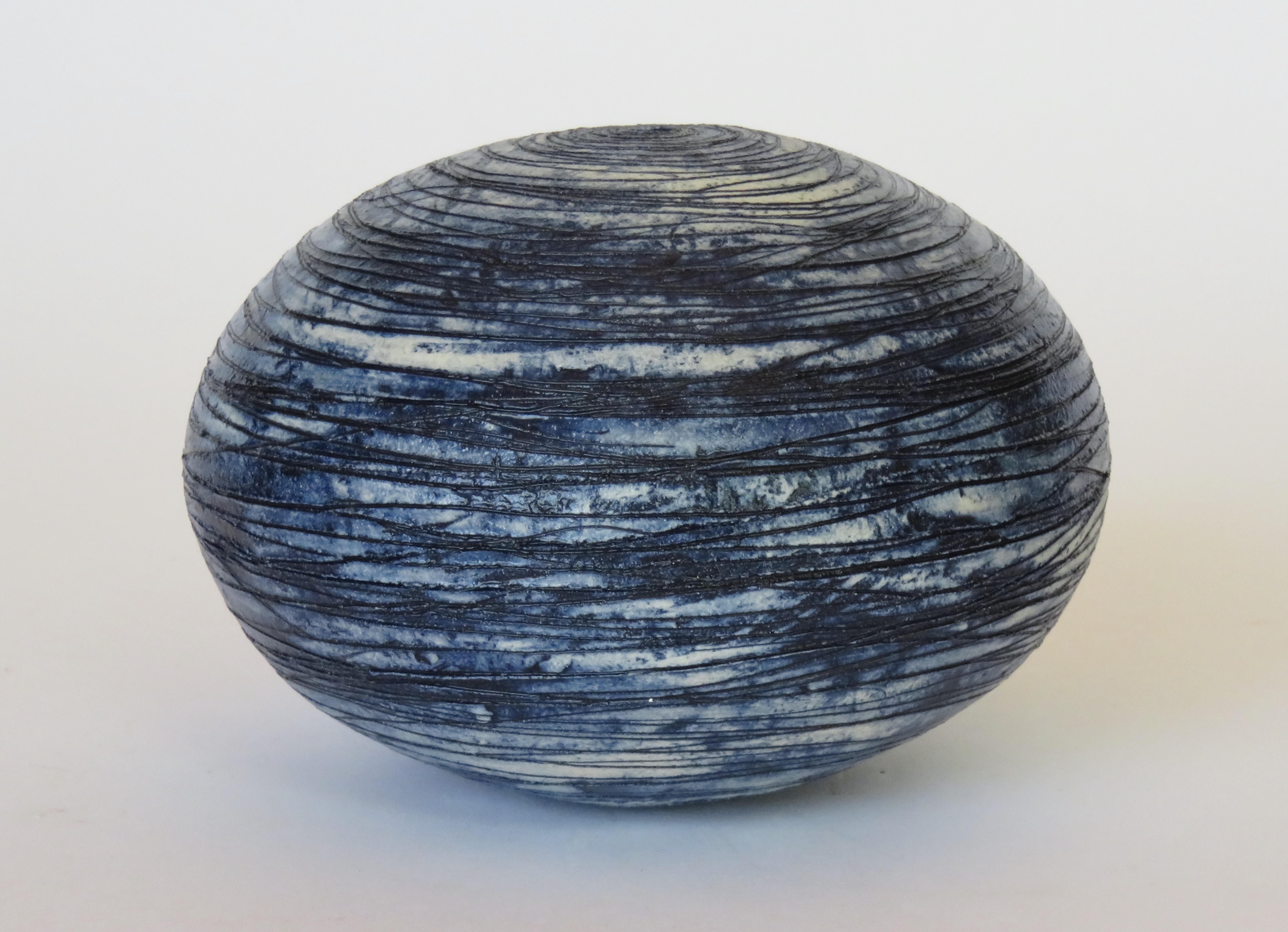 A hollow yet weighted sphere with an opening at top. It is hand carved with lines mimicking the rotation of a planet. This piece is for contemplation, meditation, to let your thoughts come and go. Or for a dried flower. Pairs beautifully with