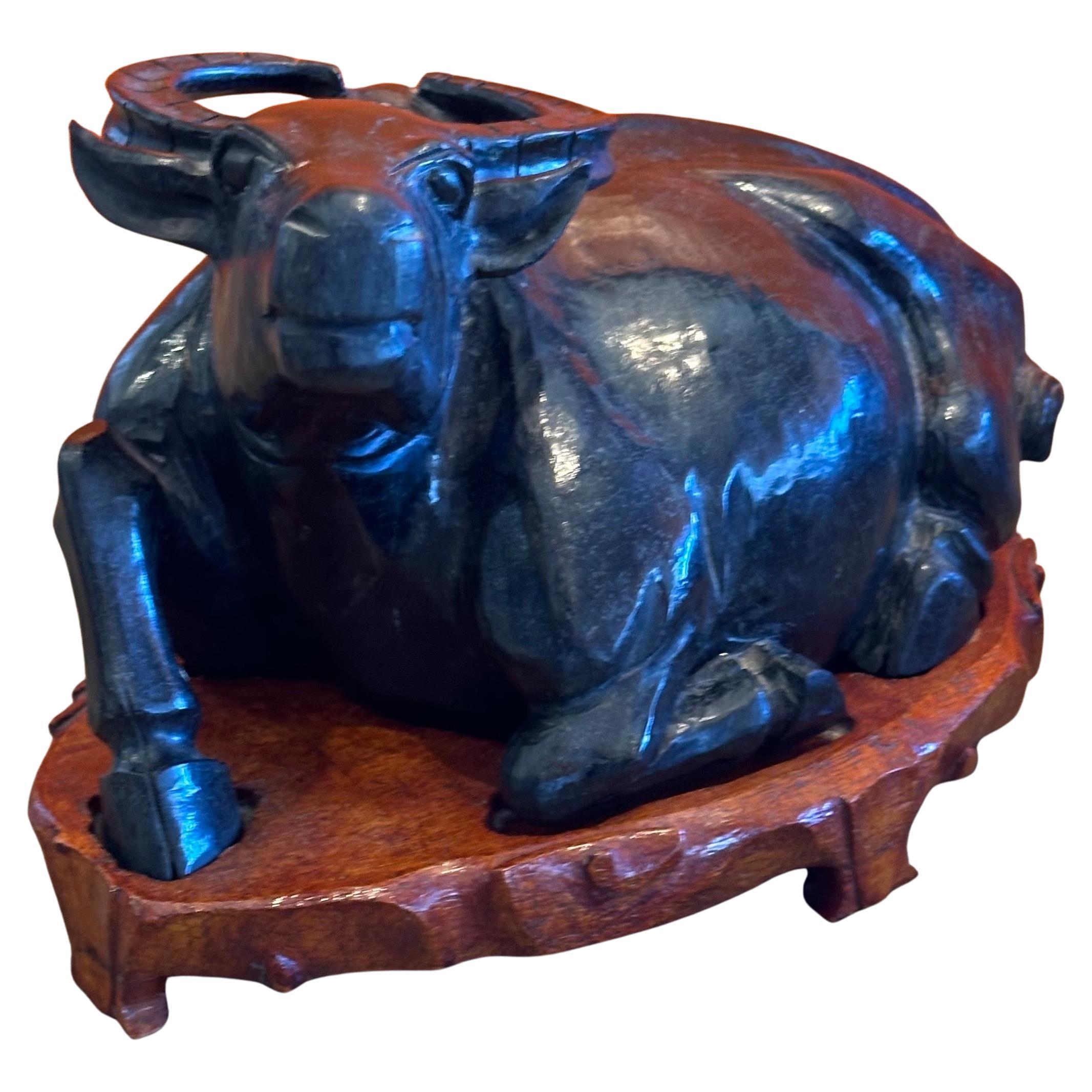 Très belle sculpture chinoise de buffle d'eau en pierre sculptée à la main sur une base en bois, vers les années 1960. La pièce est en très bon état, avec de magnifiques détails et mesure un impressionnant 11 