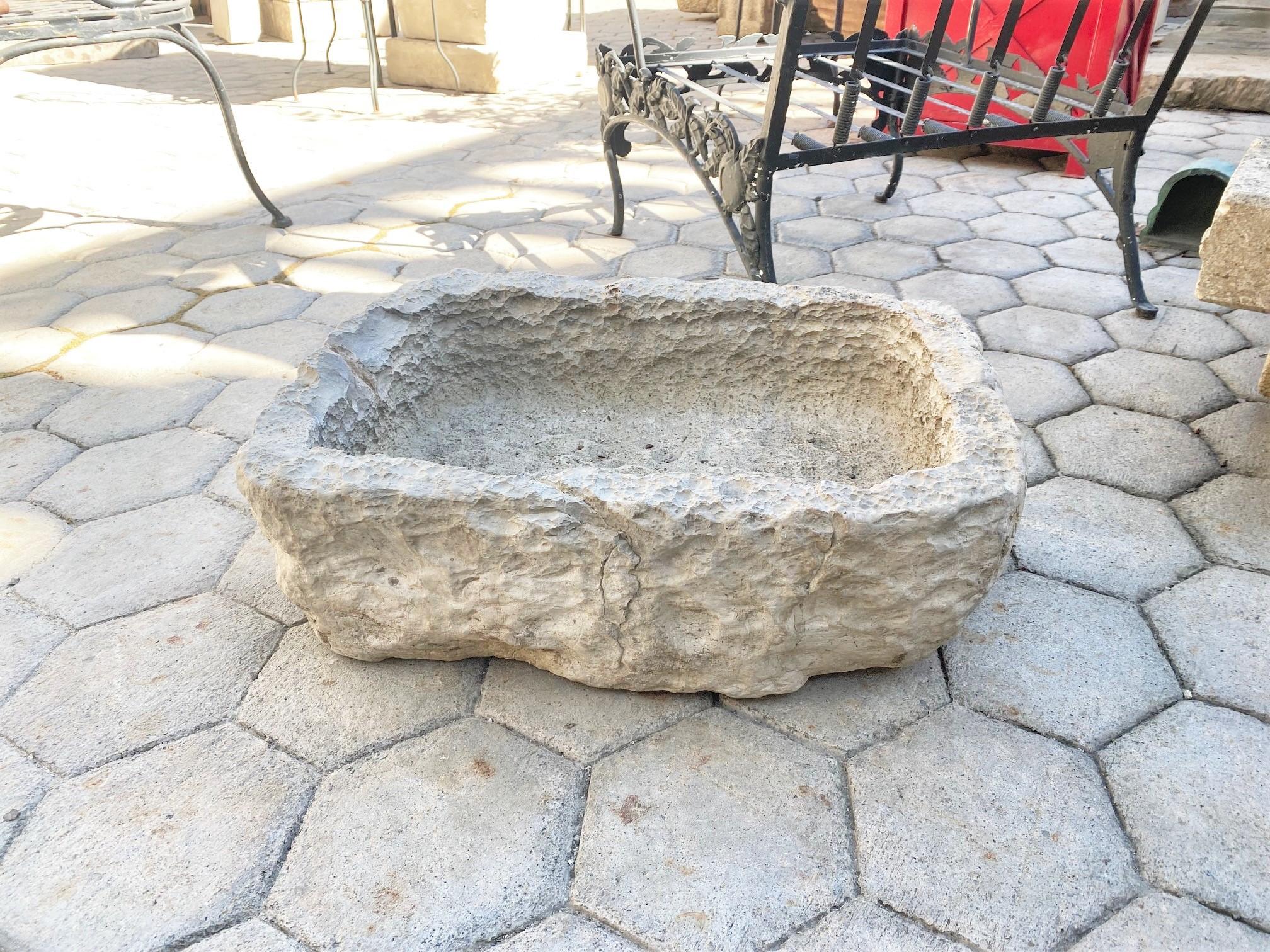 18th Century small water fountain basin of hand carved stone container. Color and patina keeps changing with the light and the seasons. this trough sink could be installed with a simple bronze metal spout or a carved stone fountain head, we have
