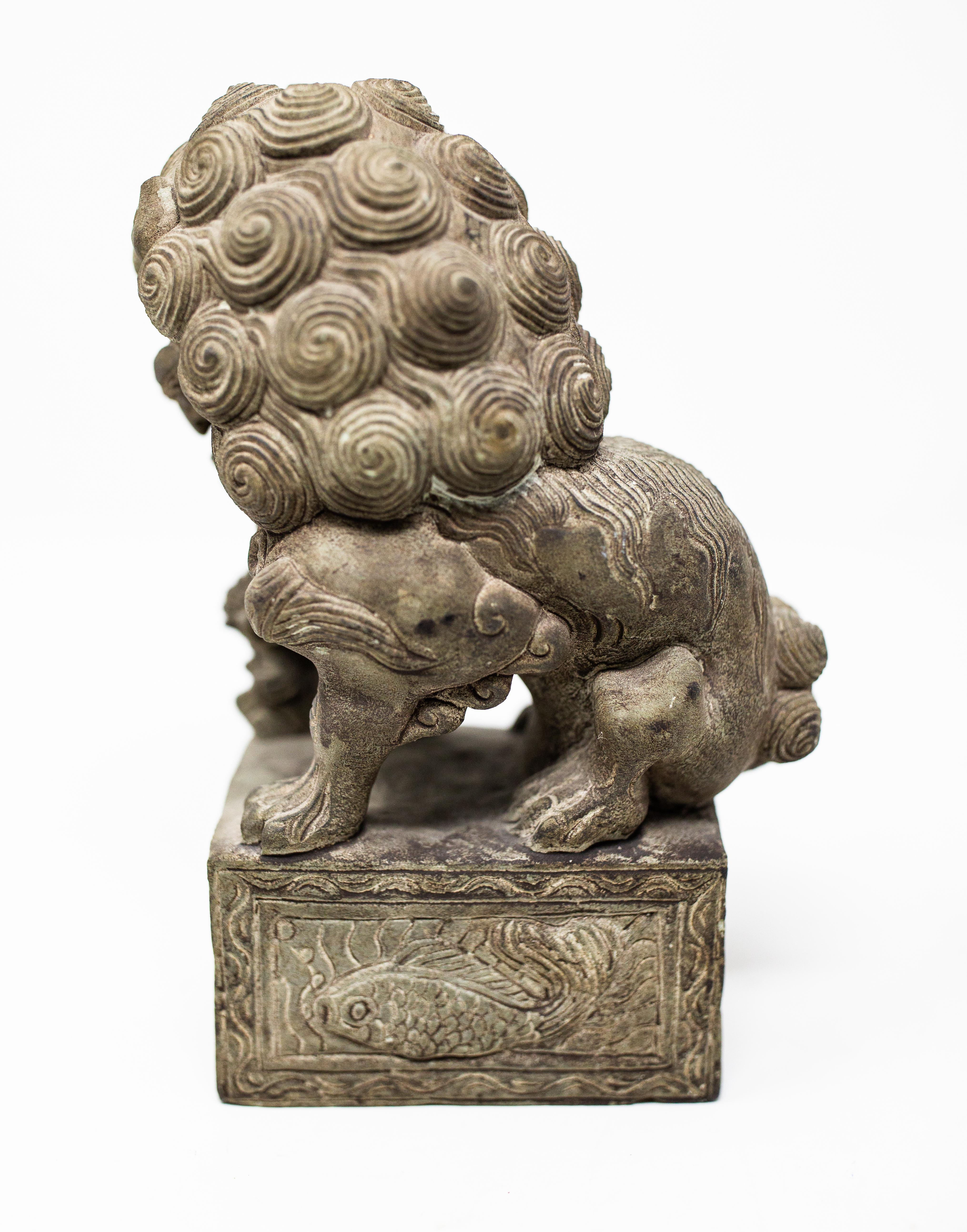 Offering this stunning hand carved stone foo dog. The foo dog is intricately carved with all the details. The base has fish that are carved all the way around. The foo dog is in its standard pose with one paw on a ball.