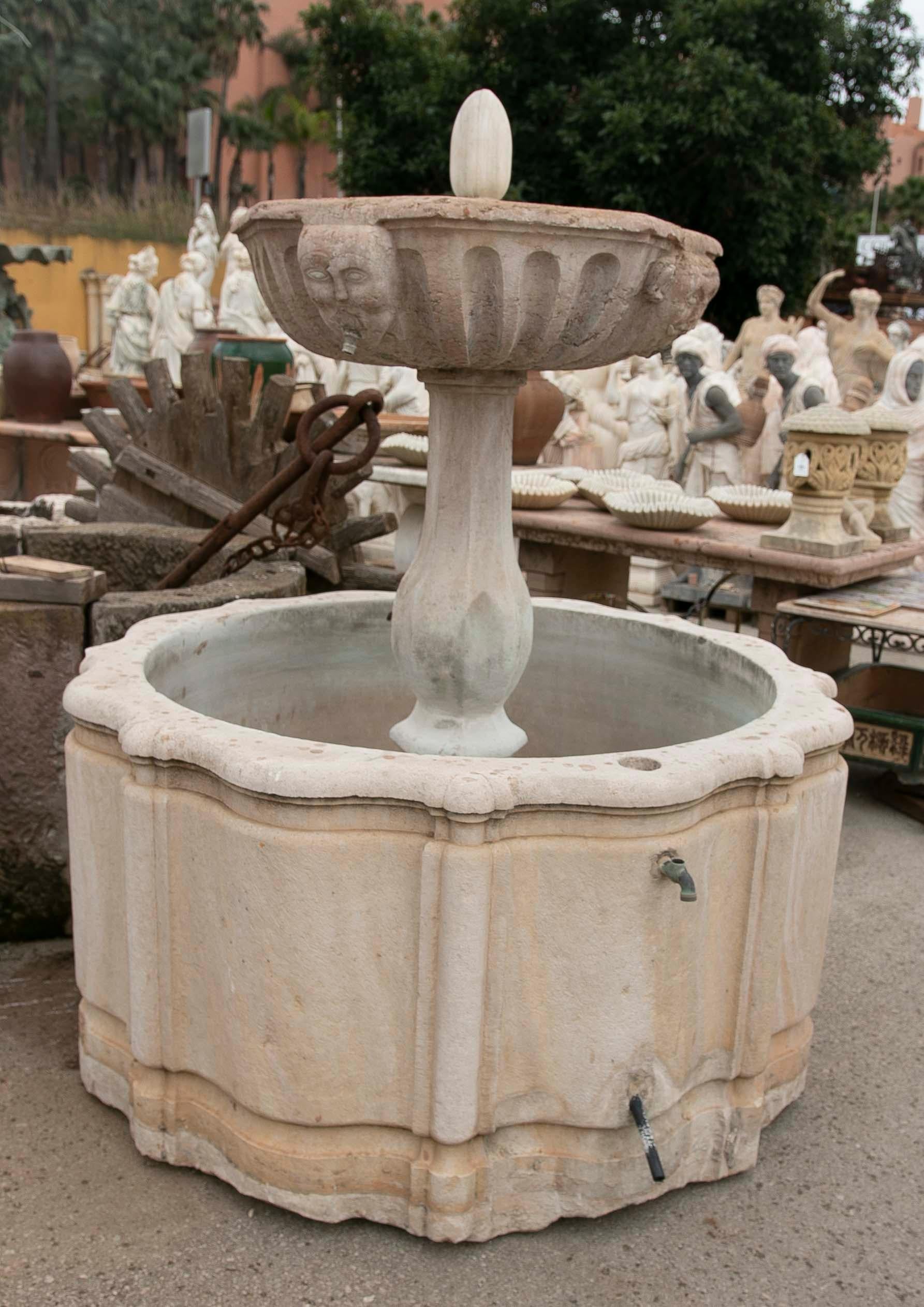 Stone fountain with a hand-carved surround and a plate decorated with faces. The central part corresponds to the 18th century with the upper plate in Italian Verona marble. The fence is made of a single block and dates from the 19th century.