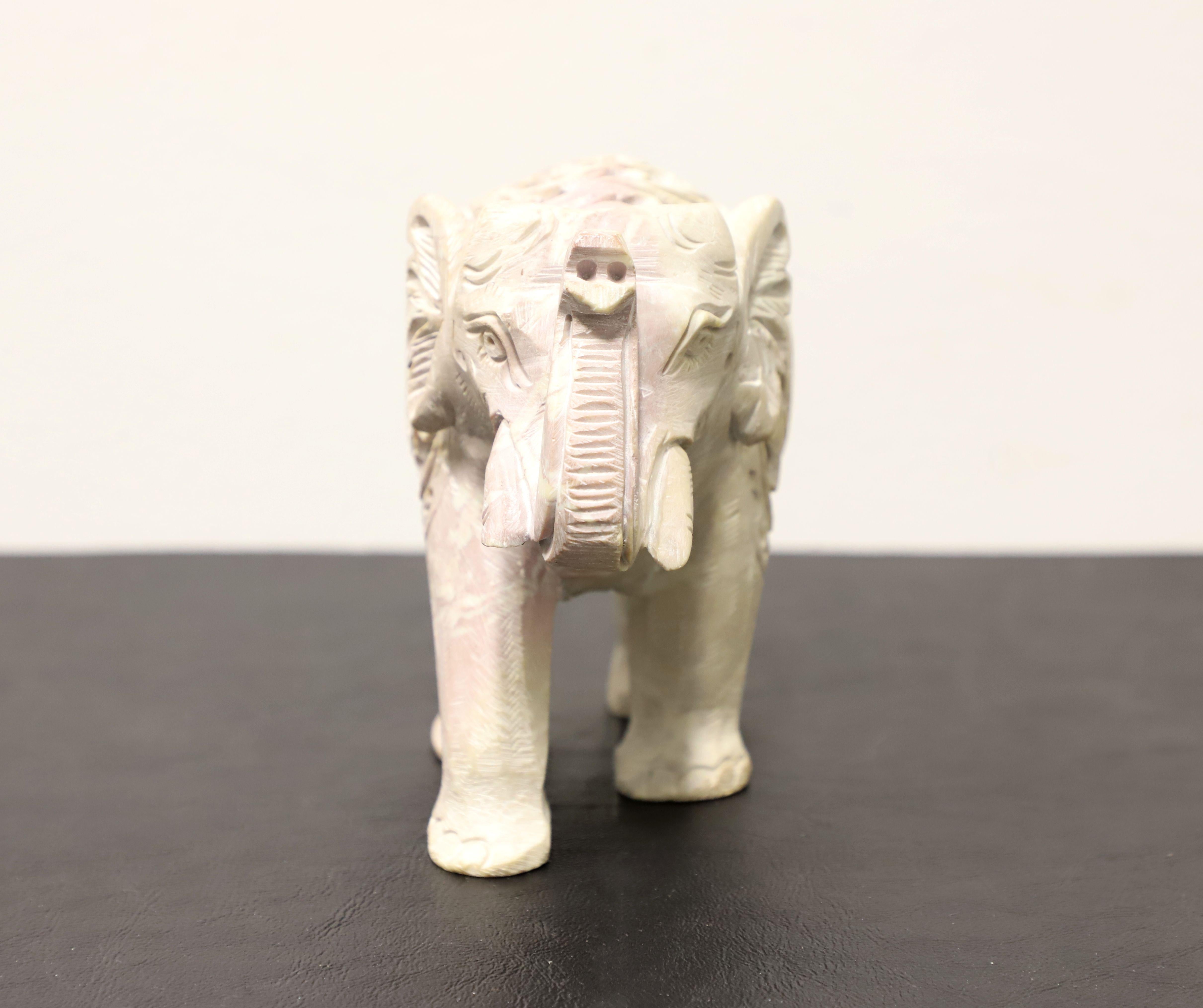 A table top sculpture in stone depicting an Indian elephant with a baby elephant inside. Unsigned, artist unknown. Intricately open carved cream color stone with exquisite detail. Made in India, in the mid 20th Century.

Measures:  3w 6.5d 5.25h,