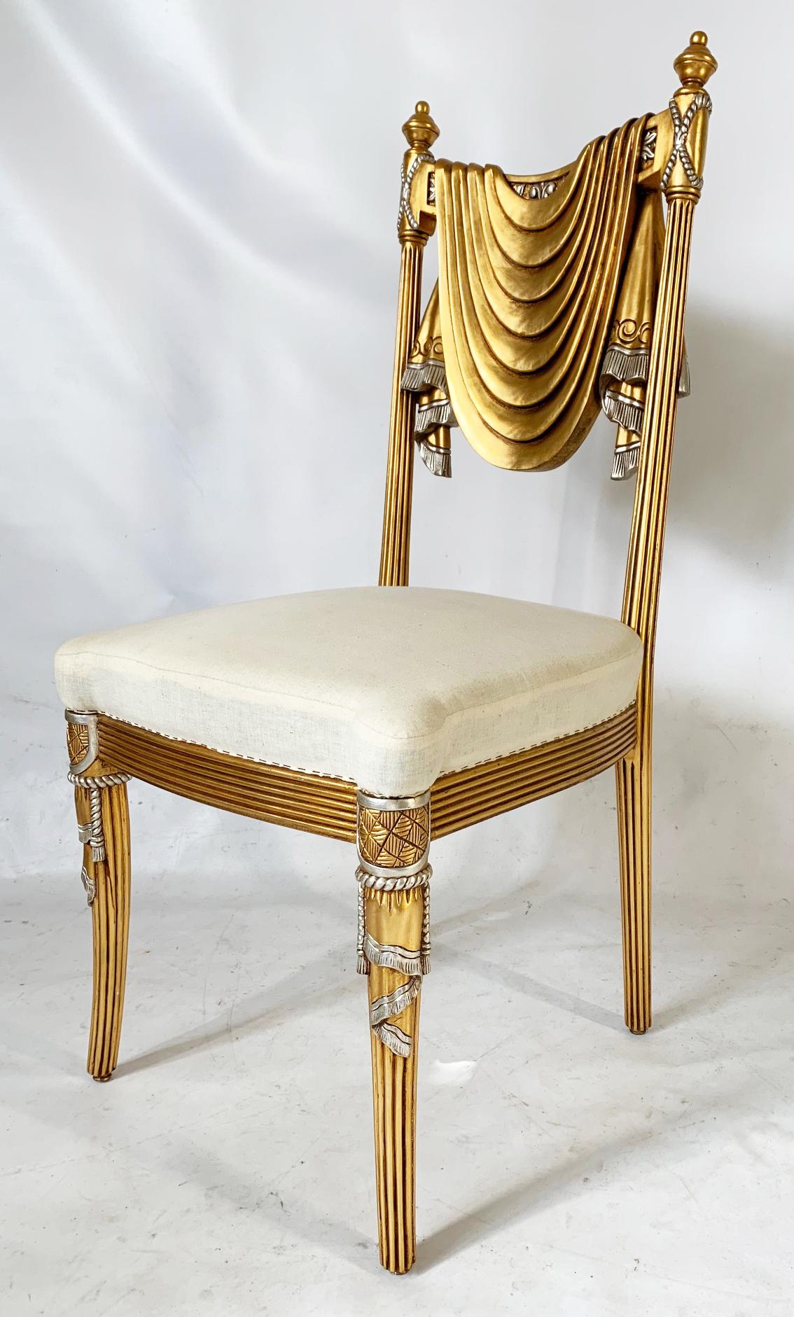 Hand carved dining chairs feature swag back motif in the form of draped fabric with tassel accents. Hand carved in Syria. Bright gold finish.  Two other finishes available, antique gold and brown stain (inquire if interested). Seats are ready for
