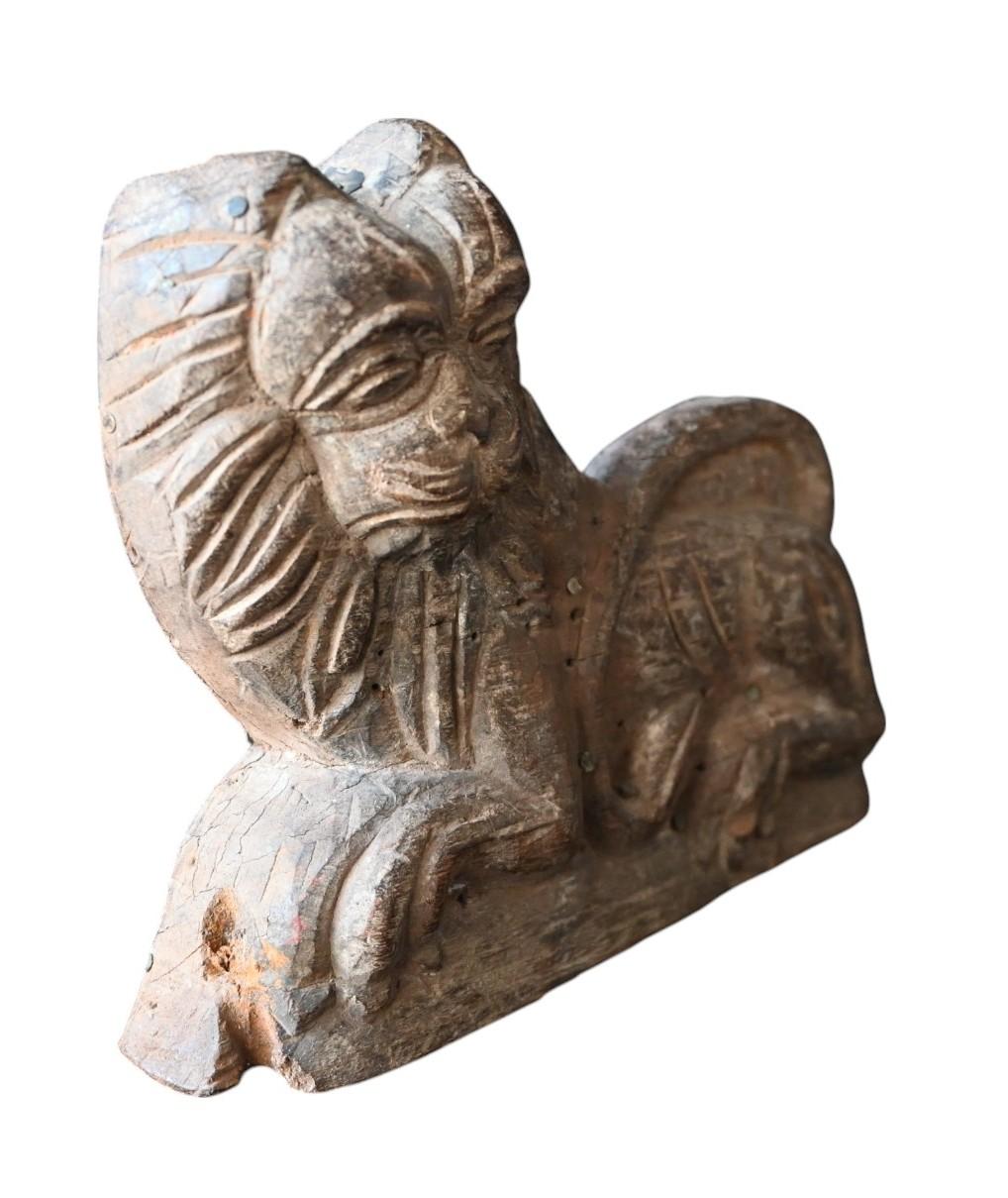 Un ornement en forme de lion finement sculpté à la main, en bois de teck massif, datant du début ou du milieu du XIXe siècle. Cette figure expressive et stylisée servait probablement de motif de garde, apposé à l'origine sur un élément cérémoniel ou