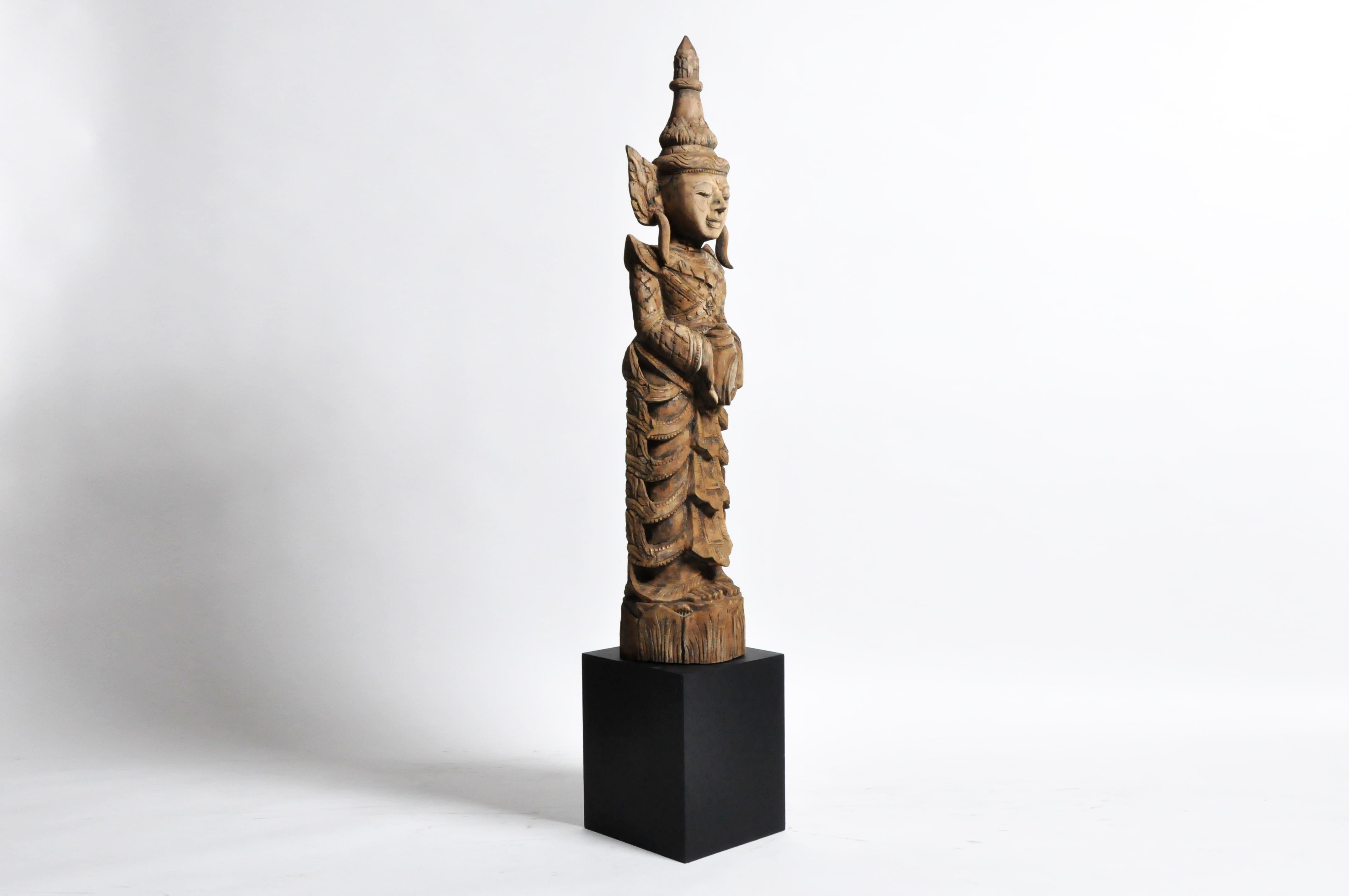 This beautiful greeting angel is from Thailand and is made from teak wood. This type of angel holds its hands clasped together in a respectful wai and wears a heavenly costume decorated with pointed winglets and a draped skirt. According to
