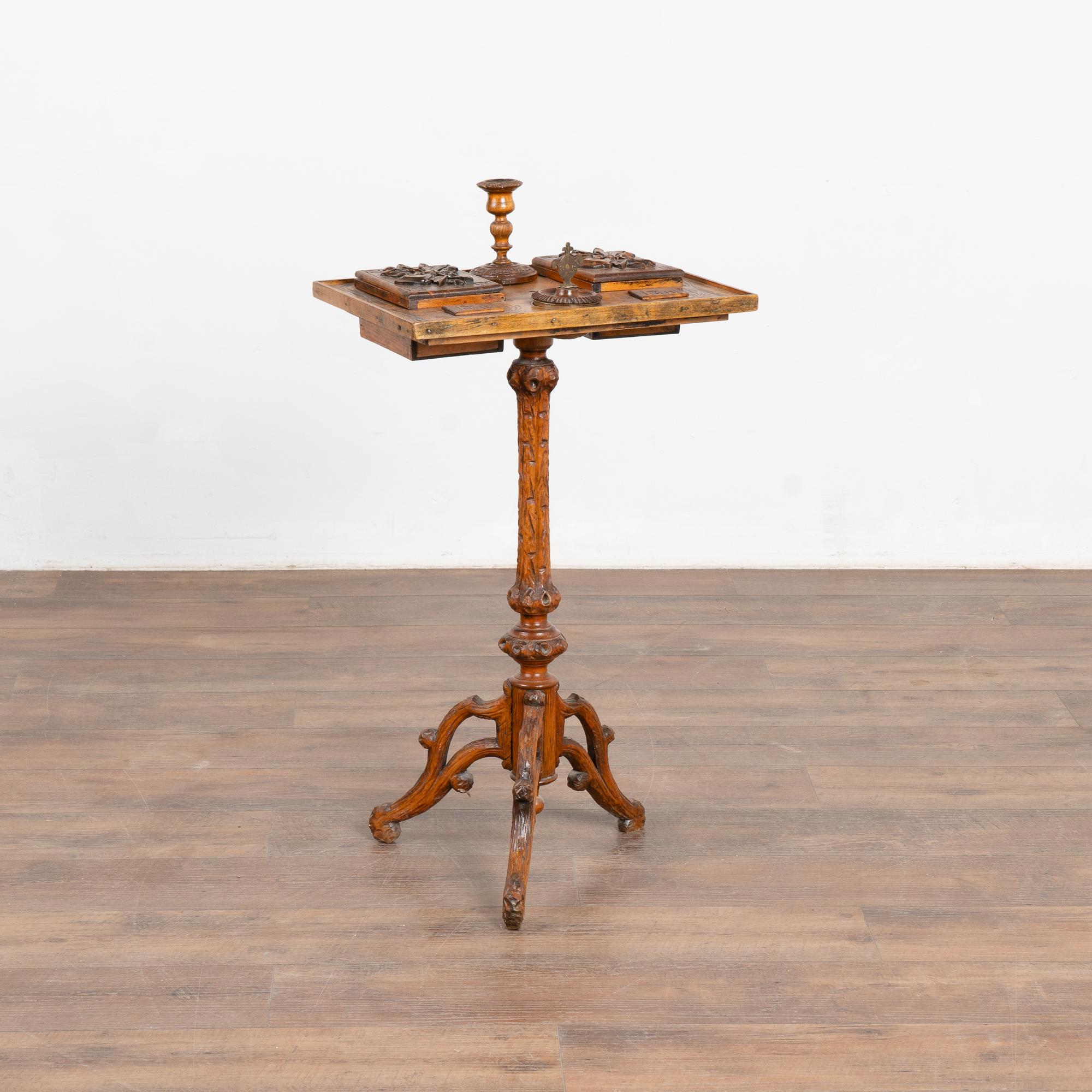 Esta fascinante mesita auxiliar sirvió originalmente como mesa de tabaco o de fumar. Observa en las fotos las cajas más grandes para pipas/cigarros, las cajas más pequeñas para tabaco/partidos, también un cenicero y un candelabro.
Son los elementos