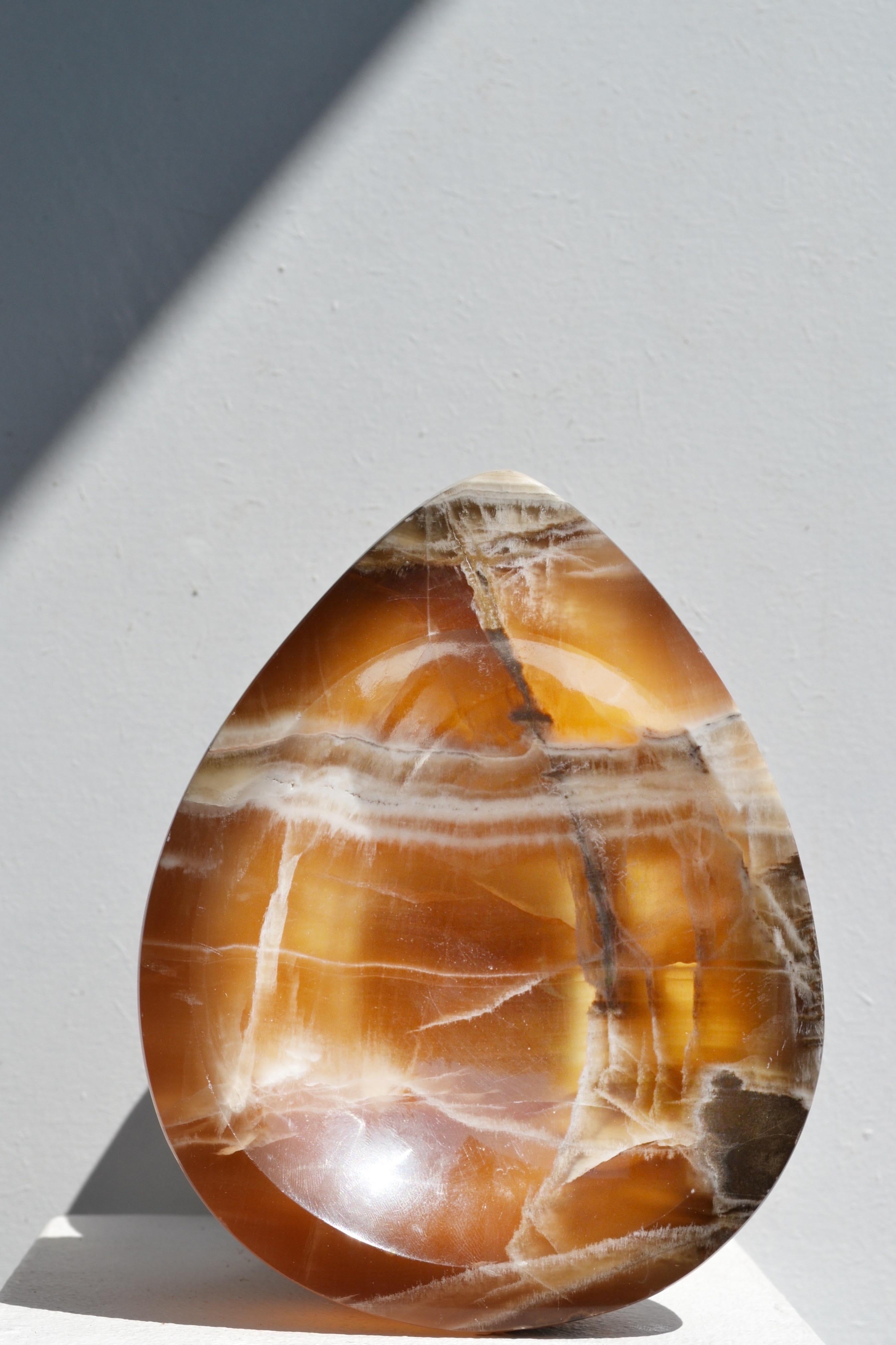 Uno splendido cestino in onice intagliato a mano, un pezzo unico artigianale degli anni '70. Il suo design naturale e organico mette in risalto splendide tonalità di beige, marrone e bianco, con sottili venature che ne esaltano il fascino autentico.