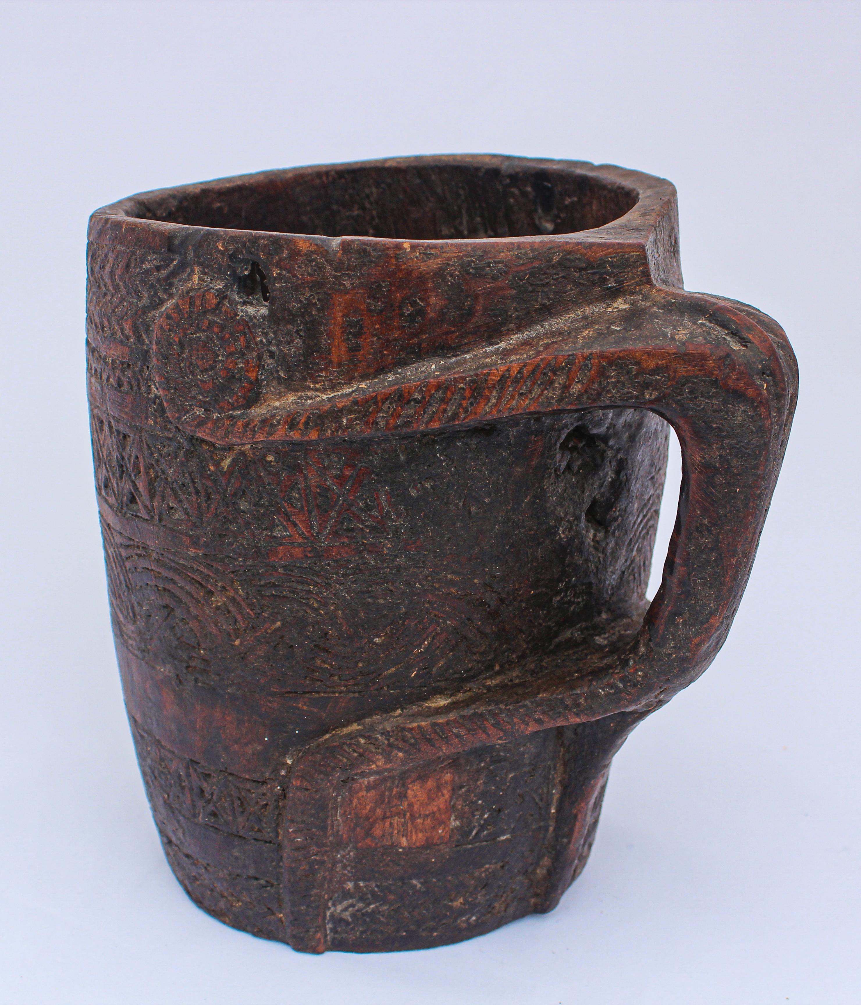 Large hand carved tribal wooden beaker Nepalese milk pot with handle.
Early 20th century antique tribal milk pot with incised pattern.
This rustic milk pot was hand carved of local hardwood in the middle hills of western Nepal, using very basic