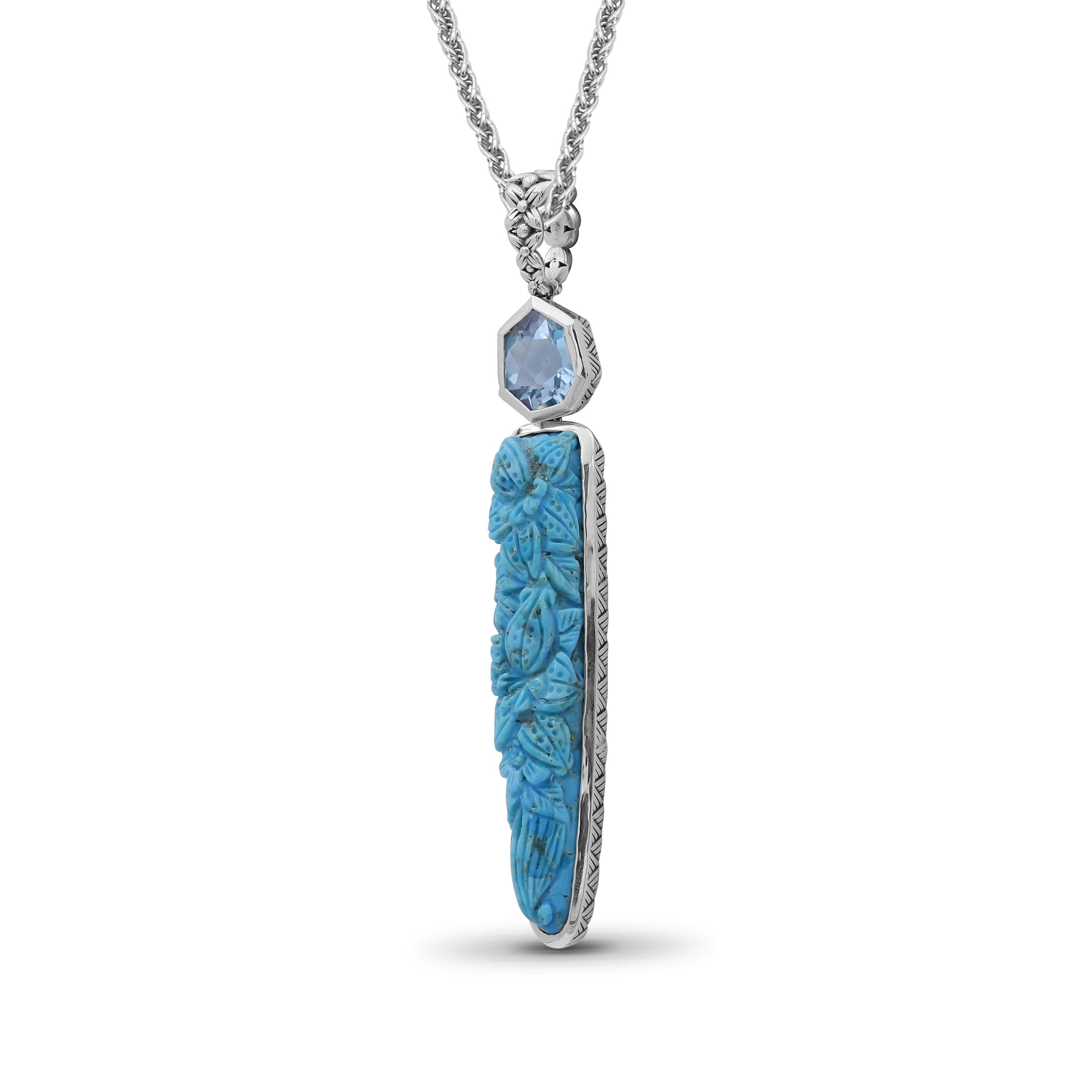 Indulge in the stunning beauty of Stephen Dweck's exquisite Hand Carved Turquoise and Faceted Galactical Blue Topaz Pendant, crafted with the utmost care and precision. This enchanting piece is a true celebration of the beauty of natural gemstones,
