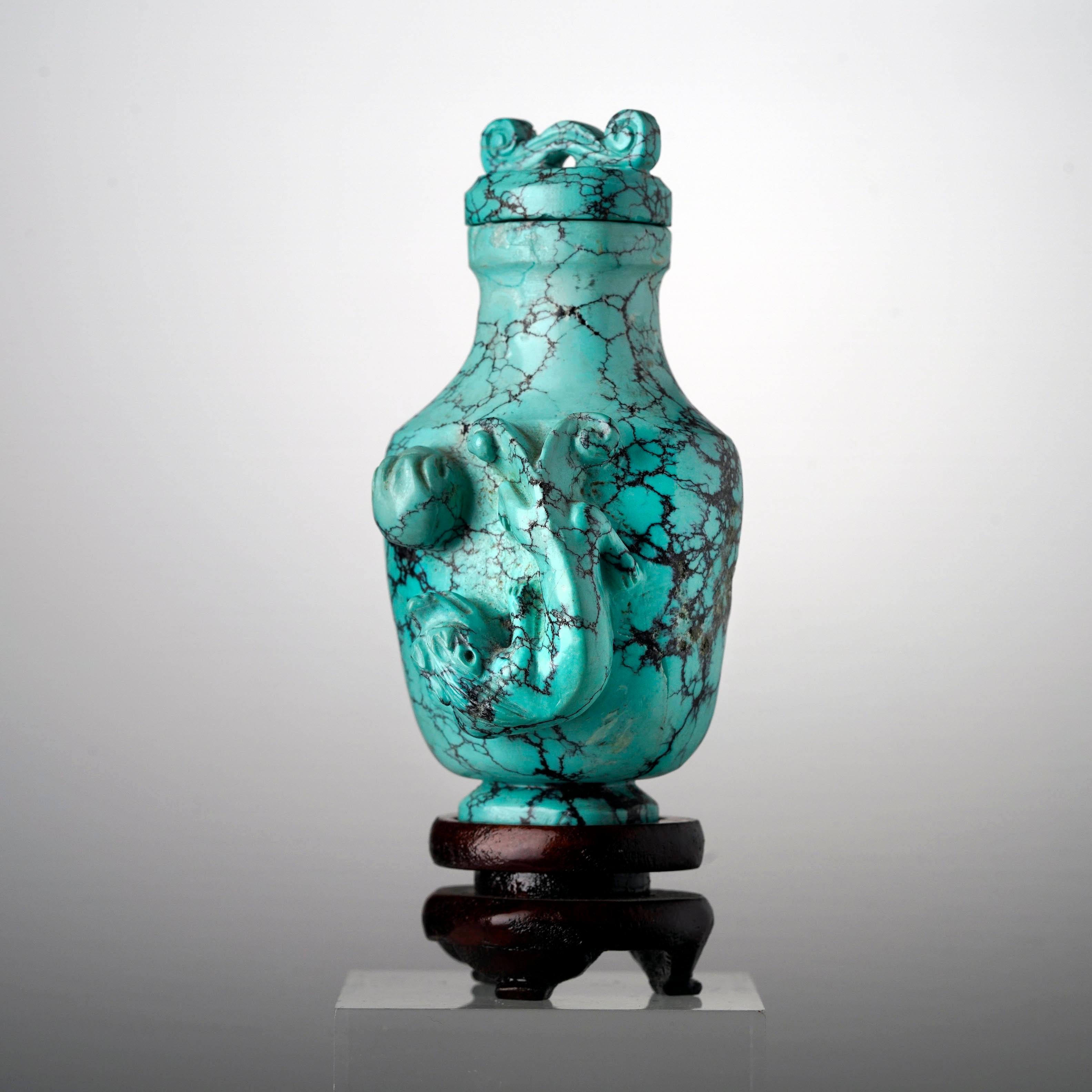 Cette tabatière sculptée à la main dans les années 1970 en Chine présente un relief impressionnant d'un dragon en mouvement, saisi en plein vol alors qu'il lance une boule de flammes. Le veinage de la turquoise (extraite en Arizona),  USA) ajoute du