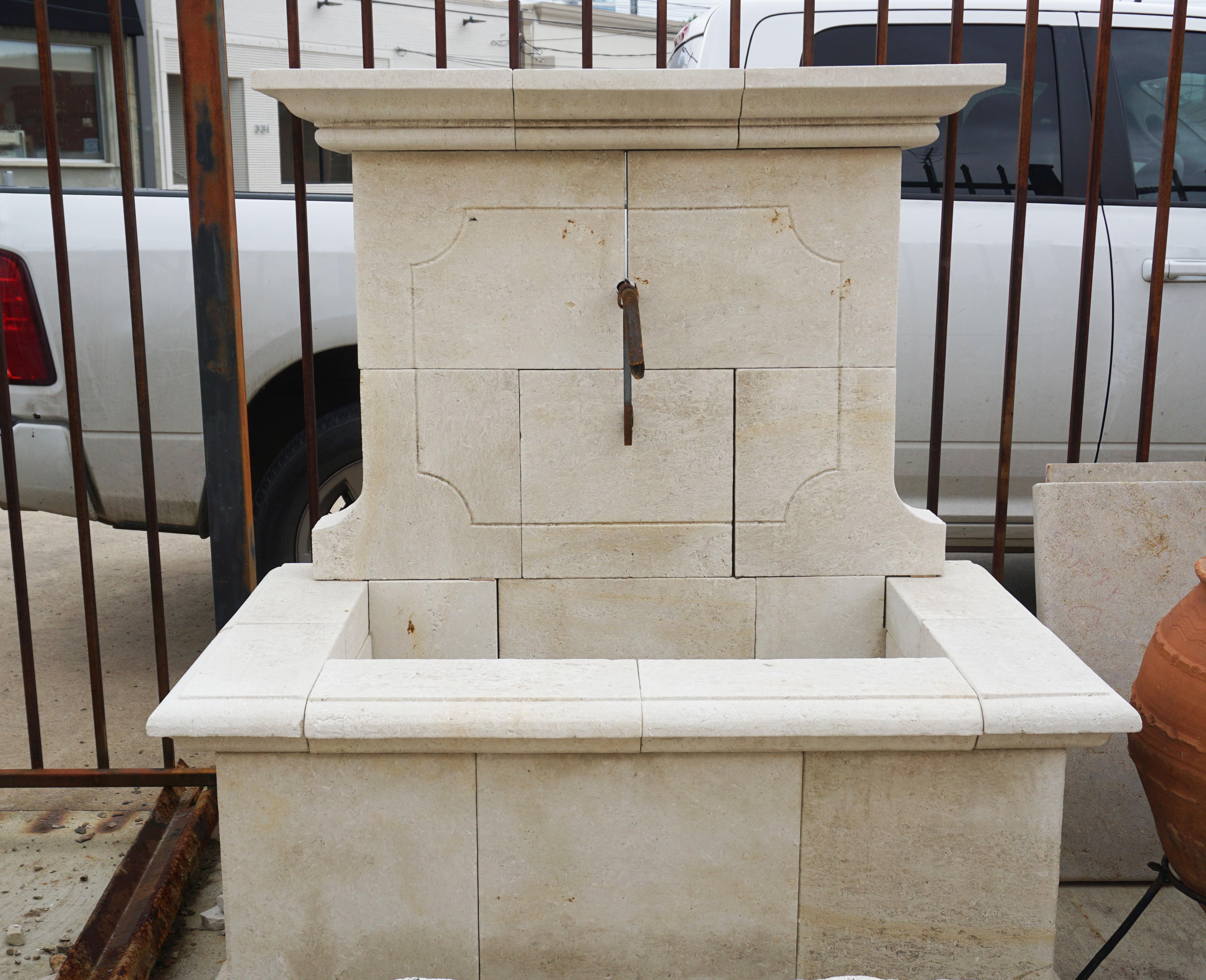 This hand carved wall fountain features a rectangular basin and originates from France. 

Measurements: 87'' H x 22'' D x 54'' W.