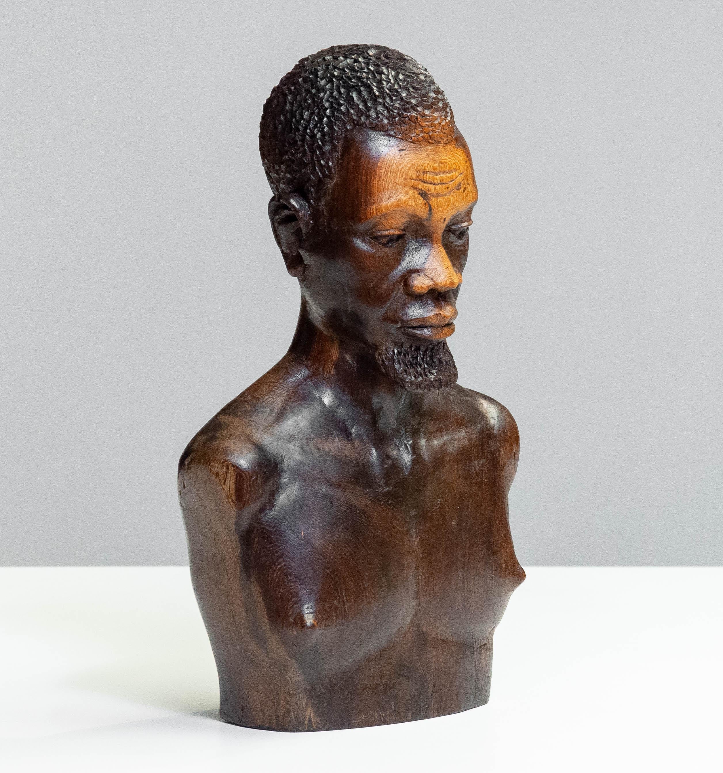 Un busto finemente intagliato a mano in legno di noce, probabilmente creato a metà del XX secolo. La scultura ritrae una figura maschile con un realismo impressionante, mostrando i tratti dettagliati del viso, i capelli strutturati e una muscolatura