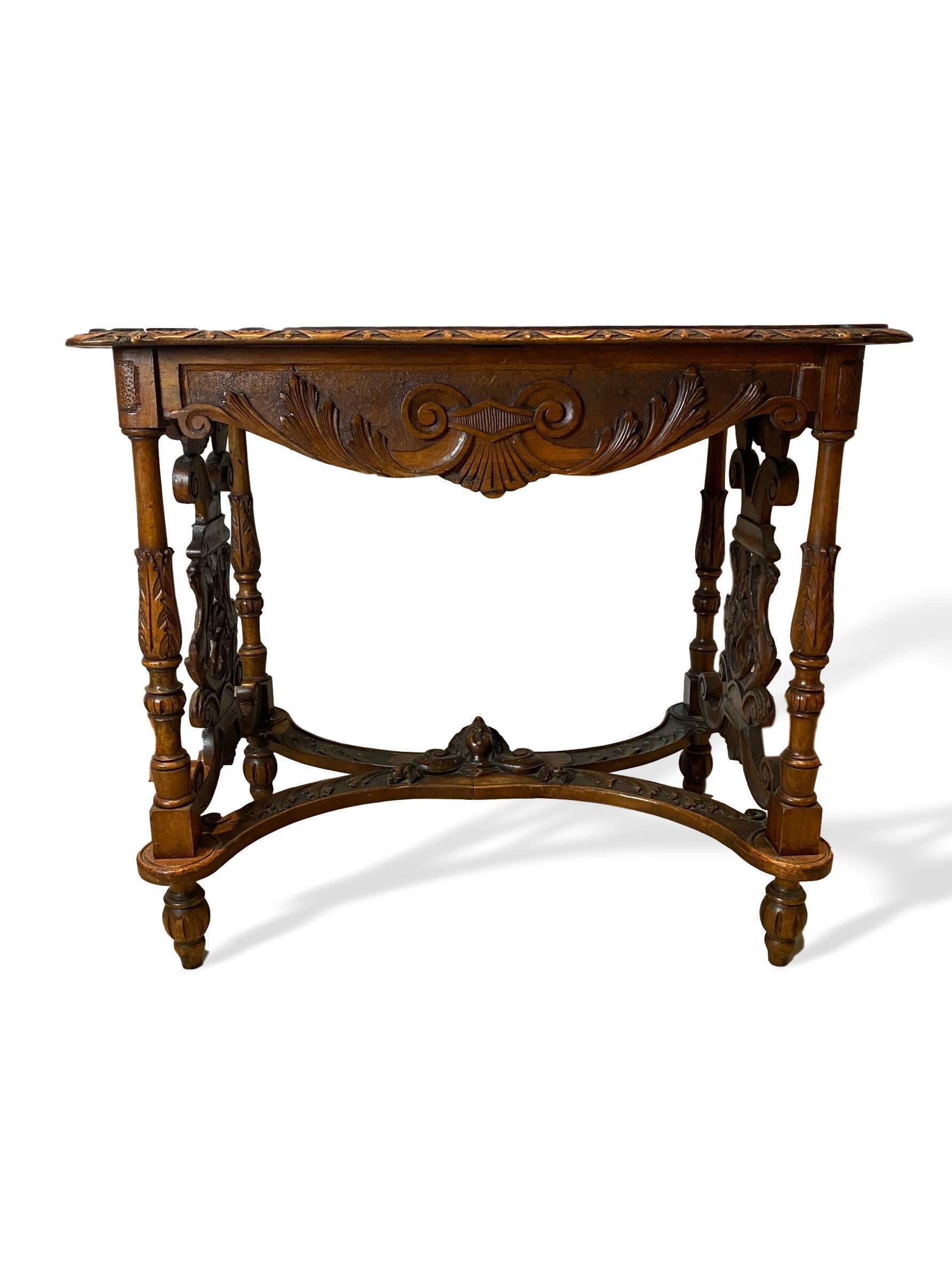 Hand carved walnut center table, Italian, circa 1880, profusely hand carved, the shaped top carved with a central motif of a sunflower, with sunflower edging, above a classically carved apron, the posts carved with stylized acanthus leaves, the