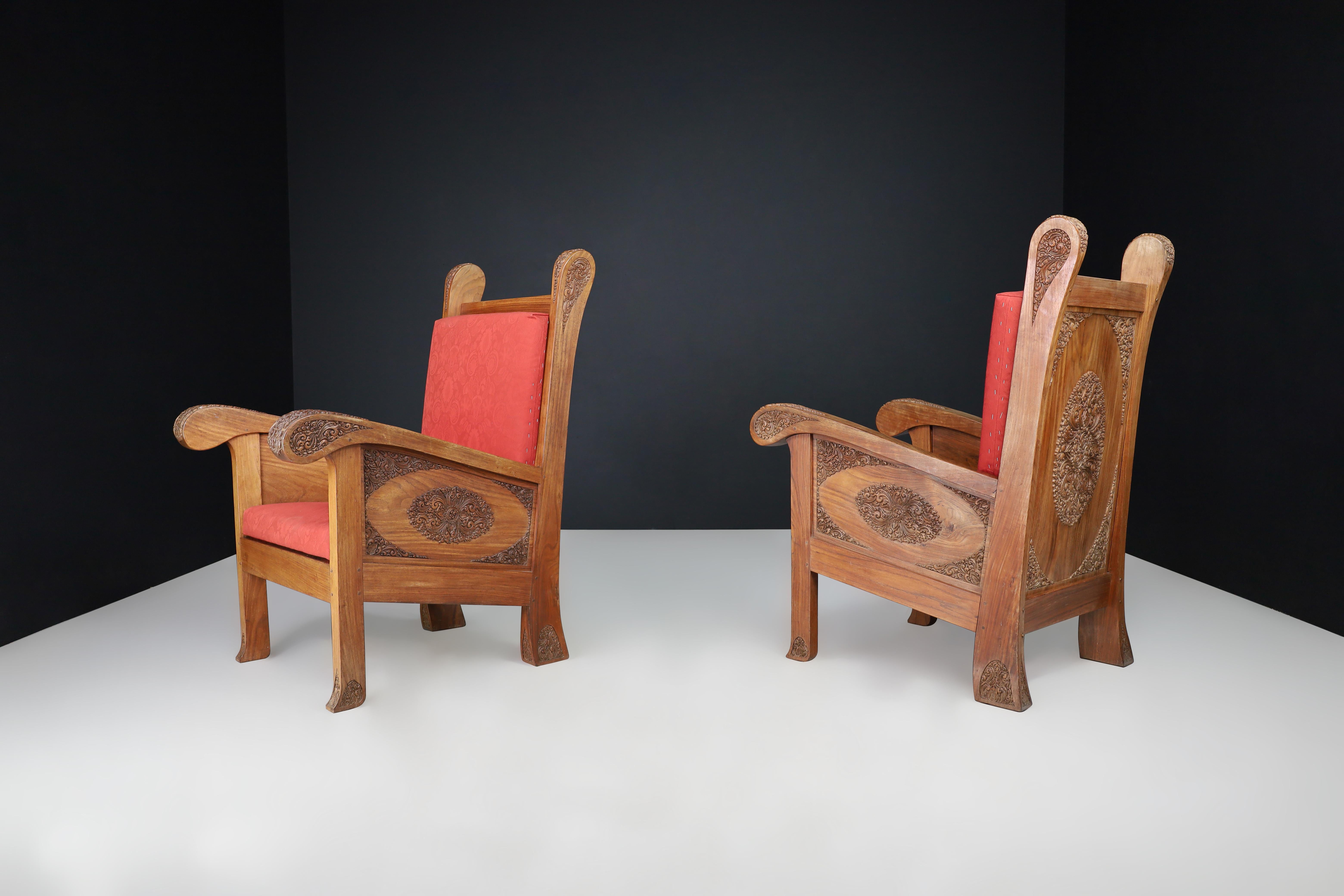 Hand-Carved Walnut High Back Chairs, Indonesia, Early 20th Century

An exceptional pair of early 20th-century high-back chairs, hand-carved from solid walnut in Indonesia circa 1930. These richly detailed pieces exemplify the masterful wood