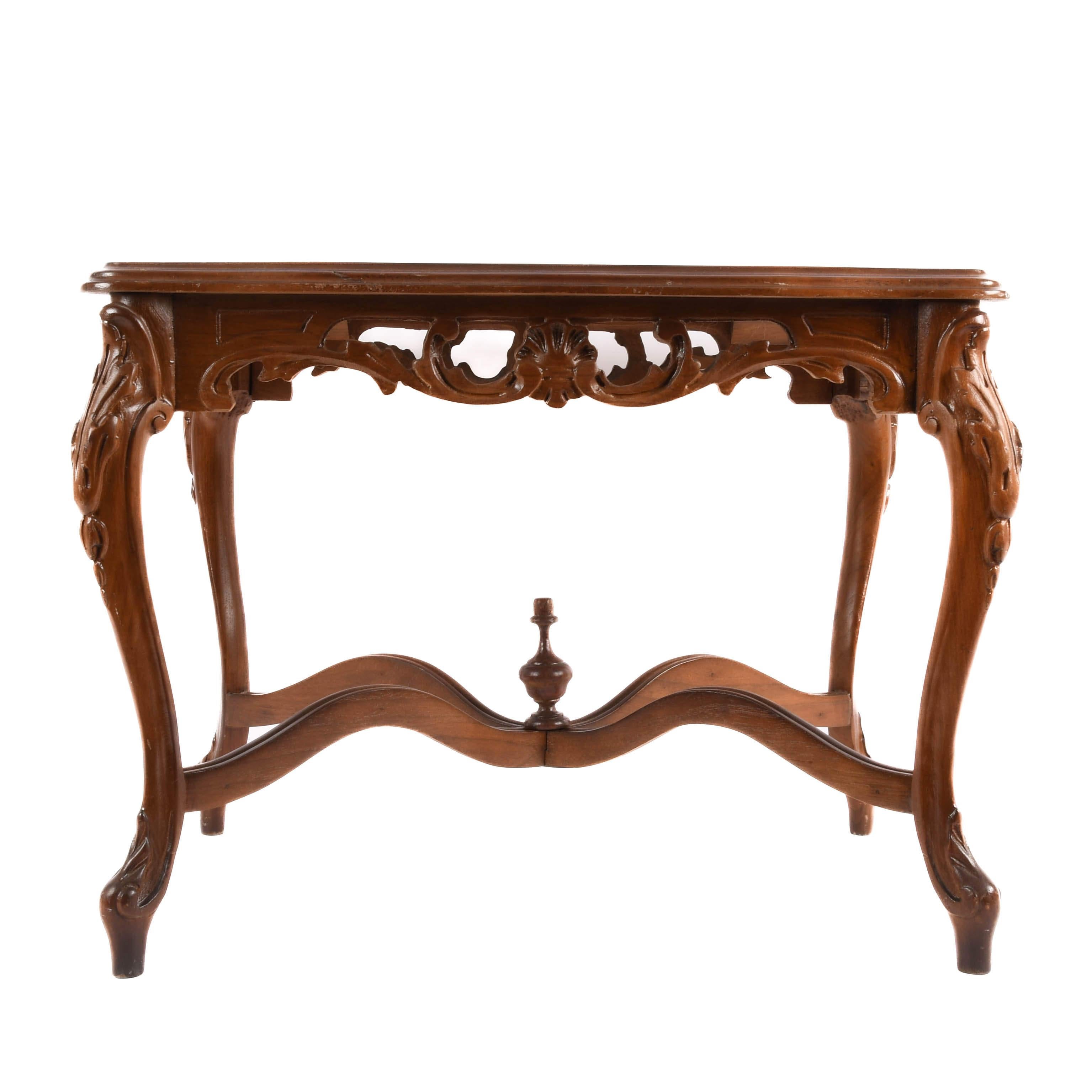 Esta elegante mesa auxiliar de nogal es un impresionante ejemplo de artesanía tallada a mano, con fluidas patas cabriolé e intrincados detalles florales que añaden un toque de encanto. Rica en carácter y elegantemente esculpida, aporta calidez y