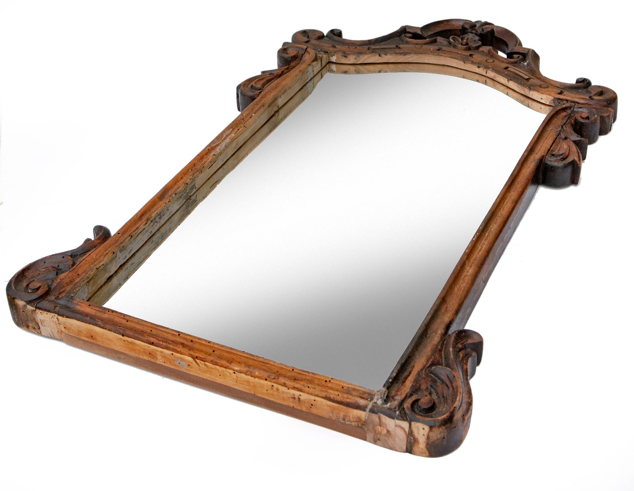 Hand-carved framed mirror has been reimagined from a walnut chairback.
The original fabric cushion has been replaced with a mirror.
The frame is solid, designed with baroque style during the Victorian period.
The carving is well executed with rich