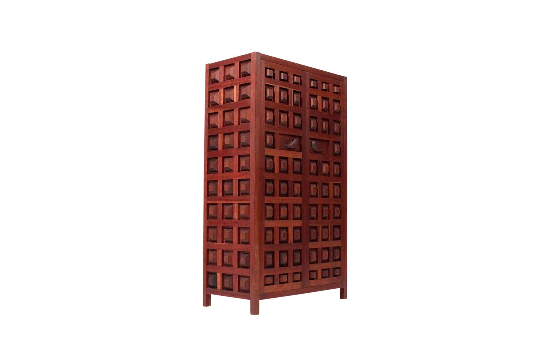 Large and unique hand carved wooden wardrobe cabinet by noted Virginian master craftsman Sam Forrest. Intricately and deeply carved, the surface is textured with a bold geometric pattern.