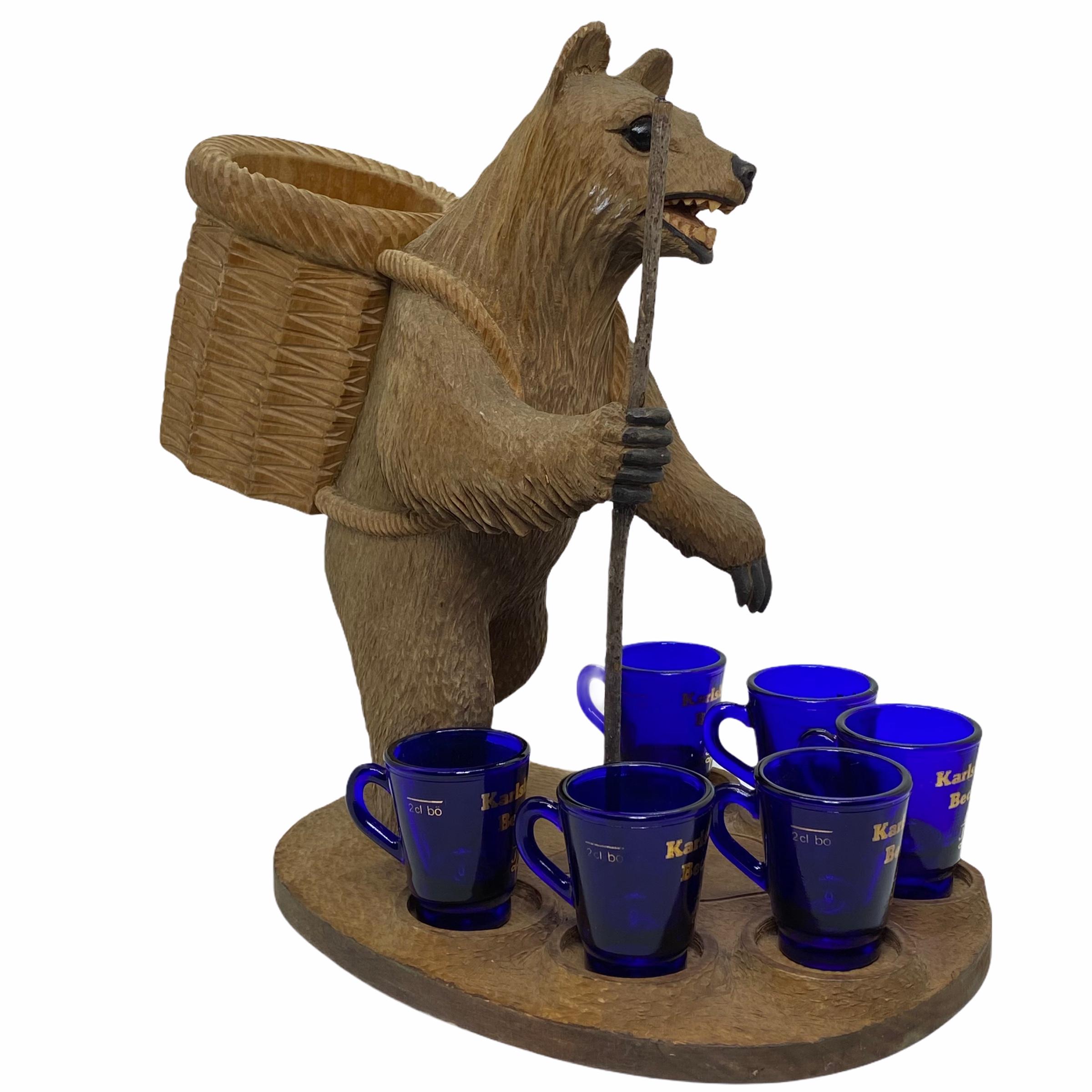 A 20th century Black Forest wood carved bear. Nice addition to your room or just for use it on your desk. Made of hand carved wood and has original Becherovka Schnaps Glasses. Signed at the base with artist signature. Found at an estate sale in