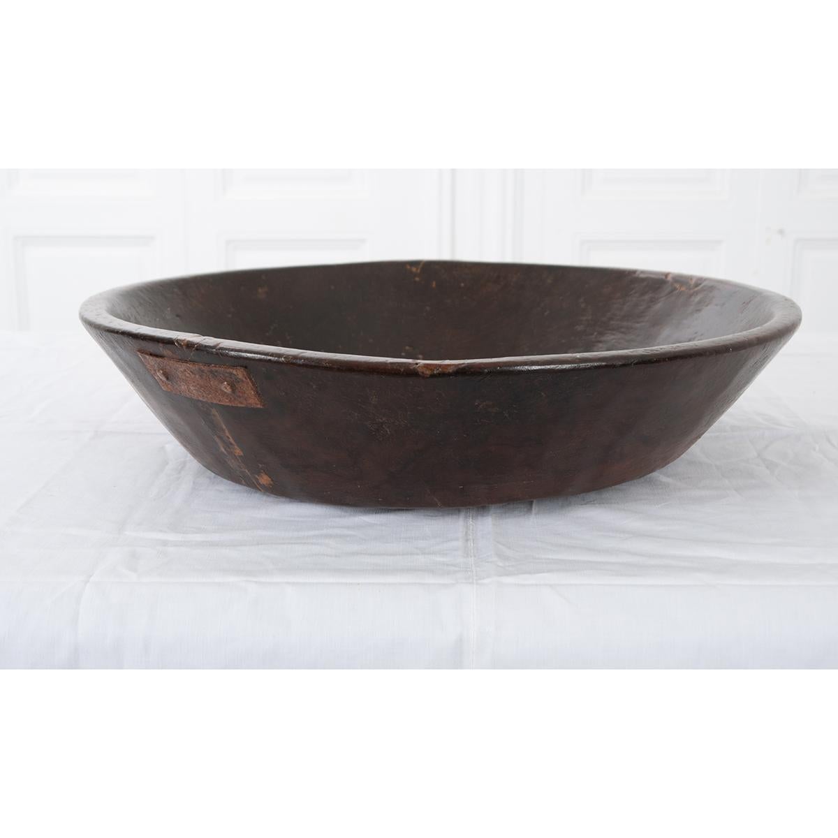 This is an English 19th century hand carved wood bowl - well used and beautiful. It has a metal patch on the side to strenghten it. The bowl would look great on any table or kitchen island. Circa 1850.