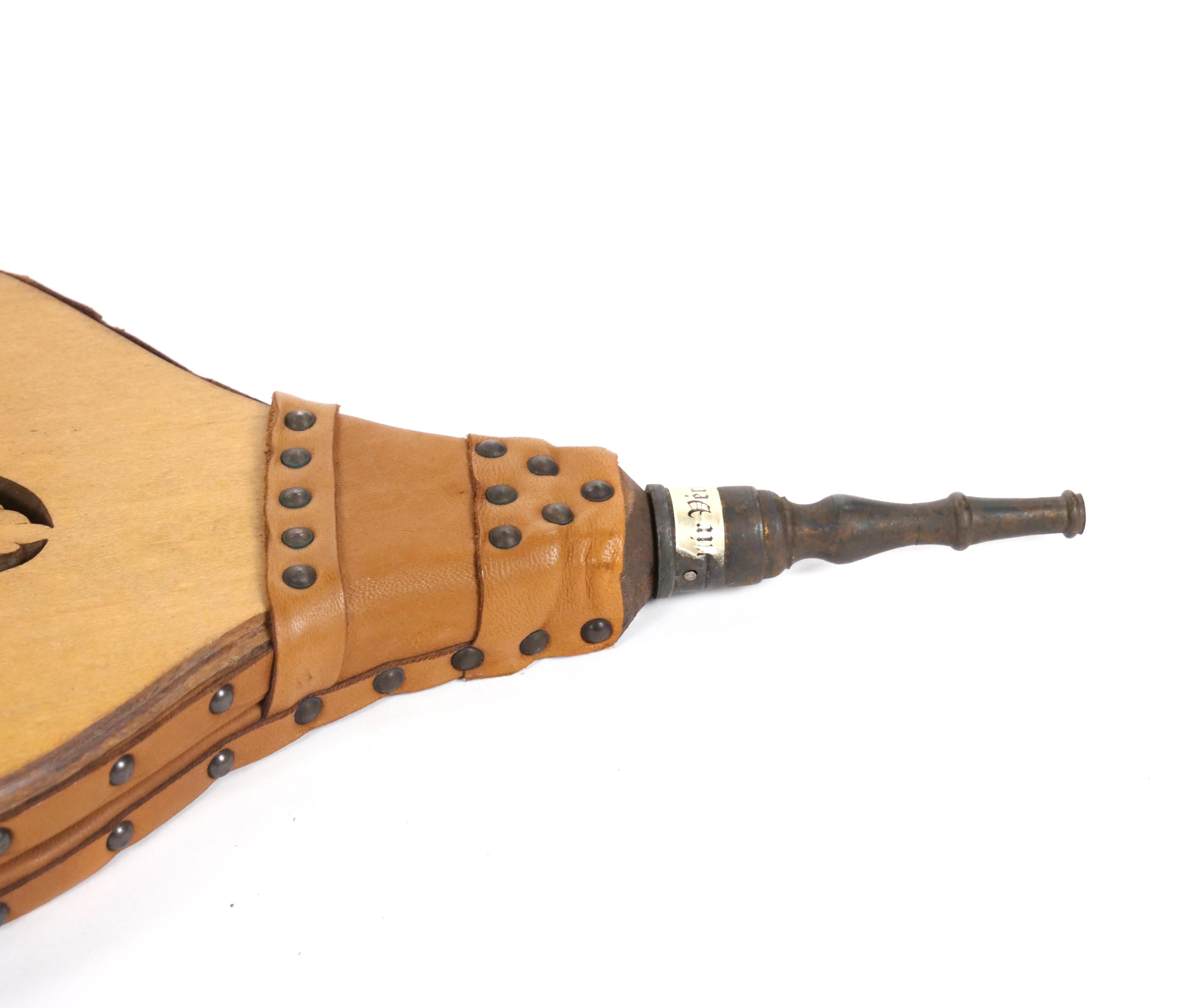 Enhance your fireplace with this elegant and functional handmade bellows, crafted in North America in the late 19th century. This exquisite piece combines quality wood, brass, and leather, offering both beauty and utility. The bellows features a