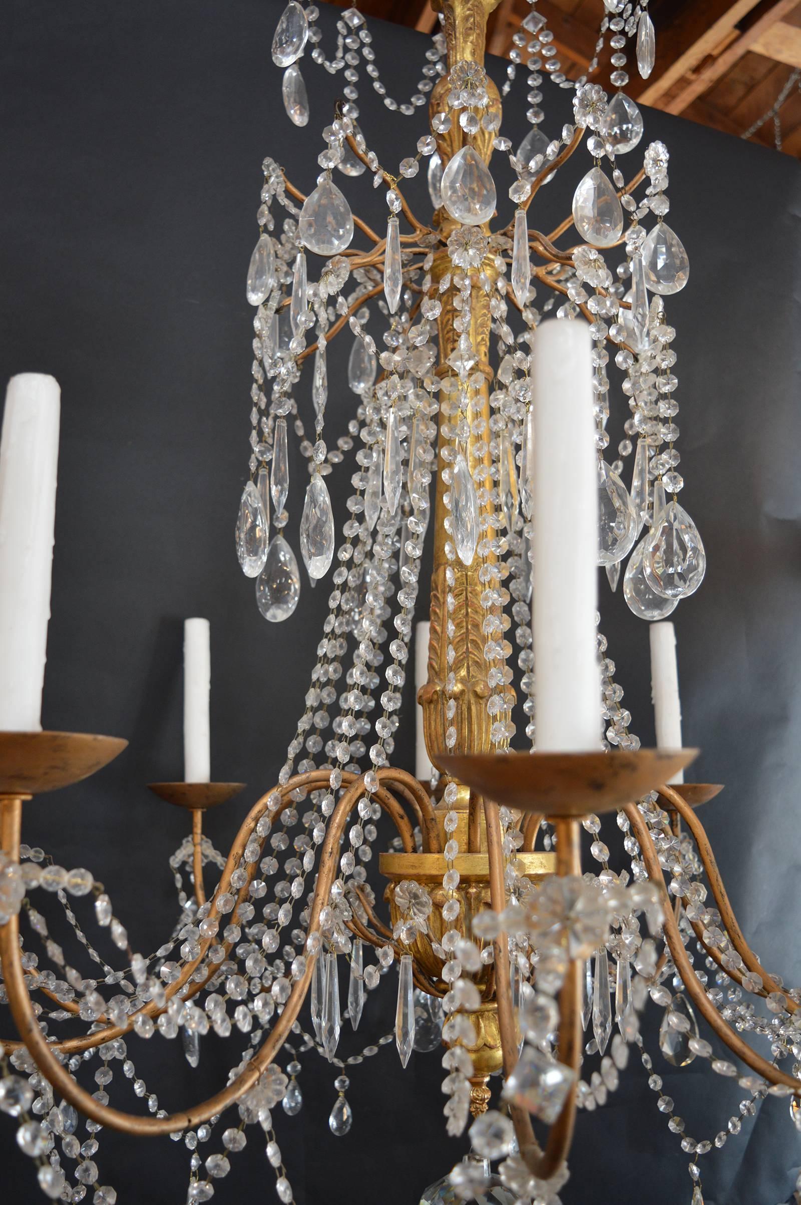 Hand-carved wood with metal arm and crystals.